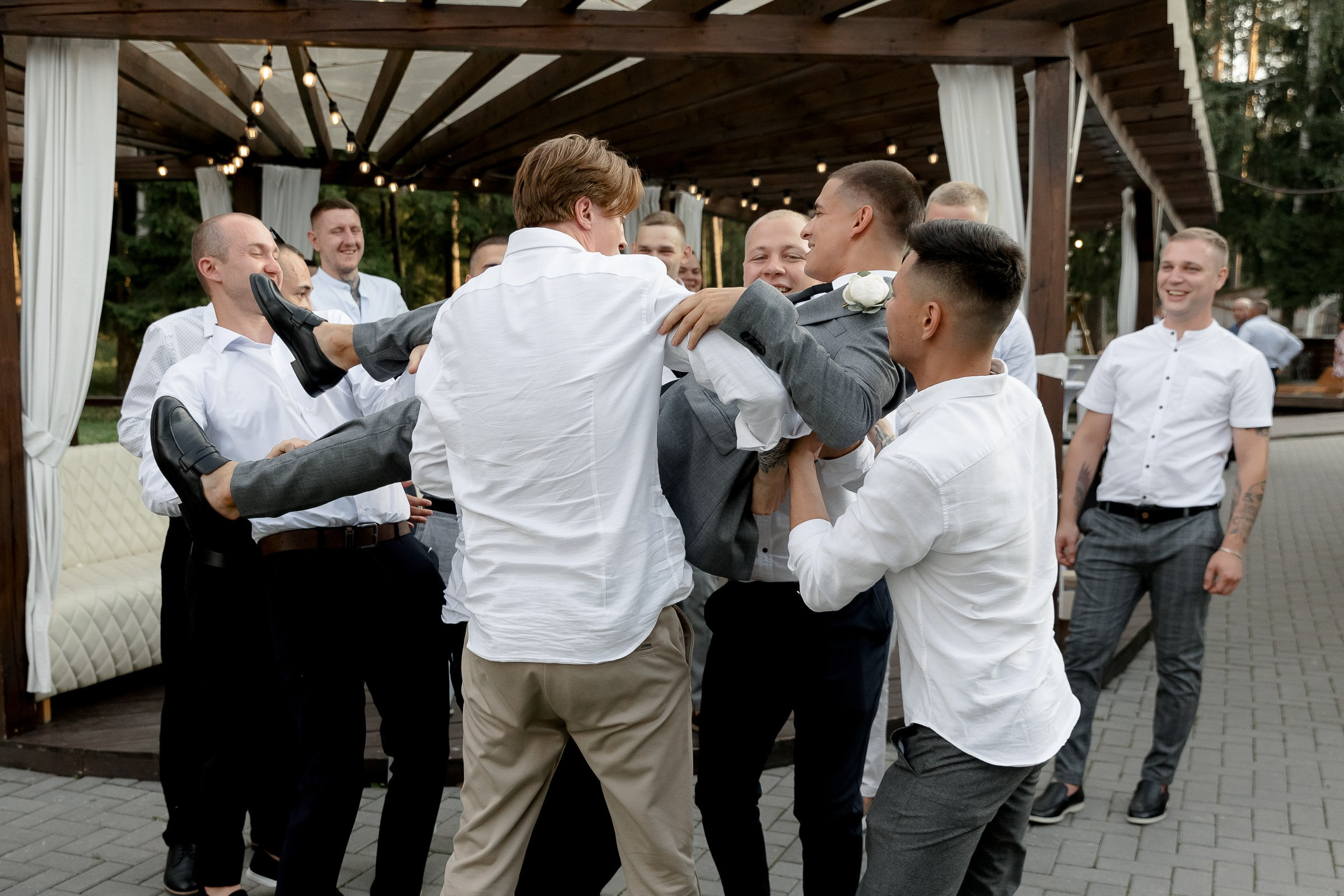 Groomsmen tossing groom, by London wedding photographer, by Tanya Bodgan.