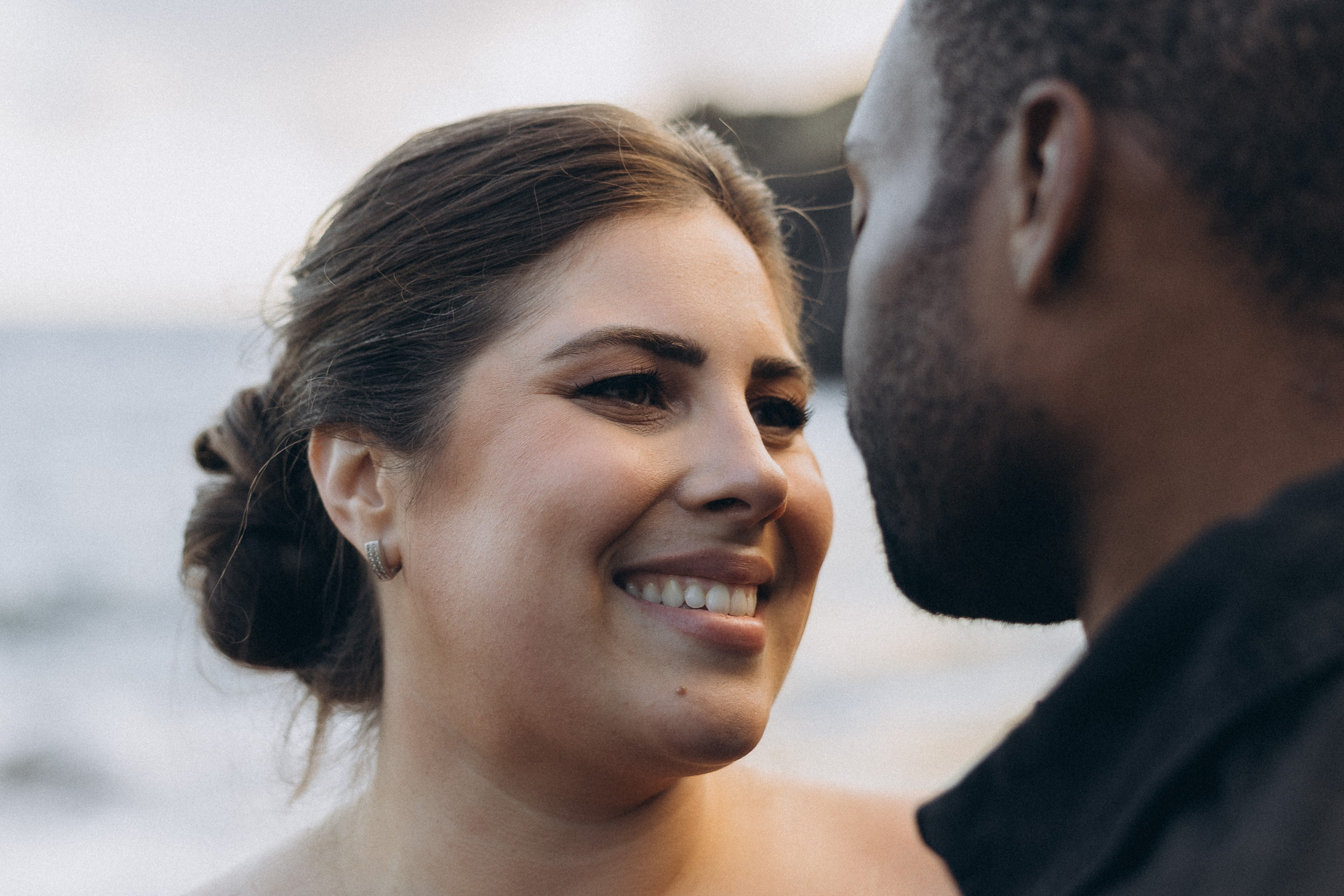 A glowing expectant mother standing on a cliff overlooking the ocean in Madeira, her dress flowing gently in the wind as the golden sunset casts a warm glow.