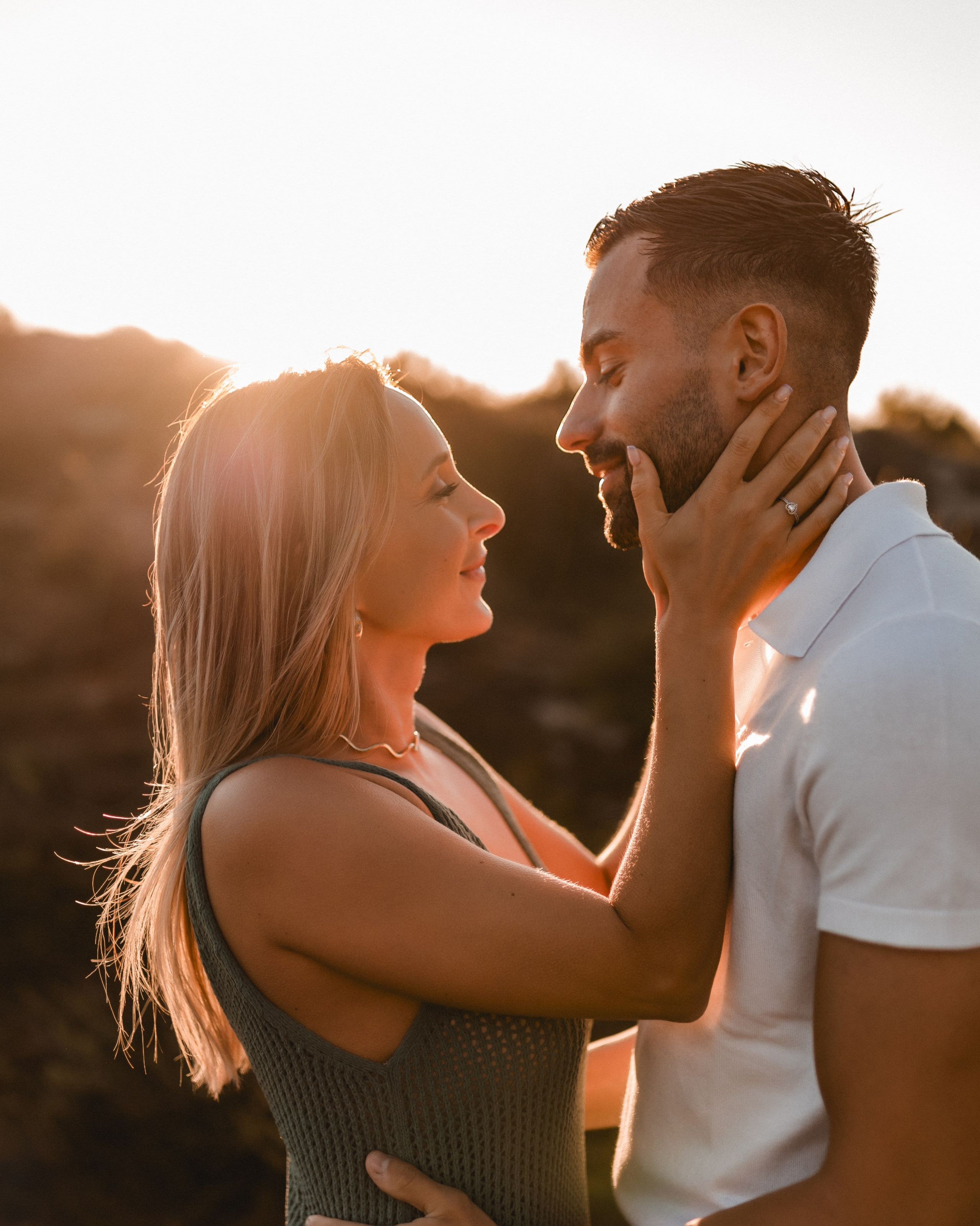 Casal apaixonado trocando olhares num final de tarde dourado durante sessão de noivado perto de Famalicão.