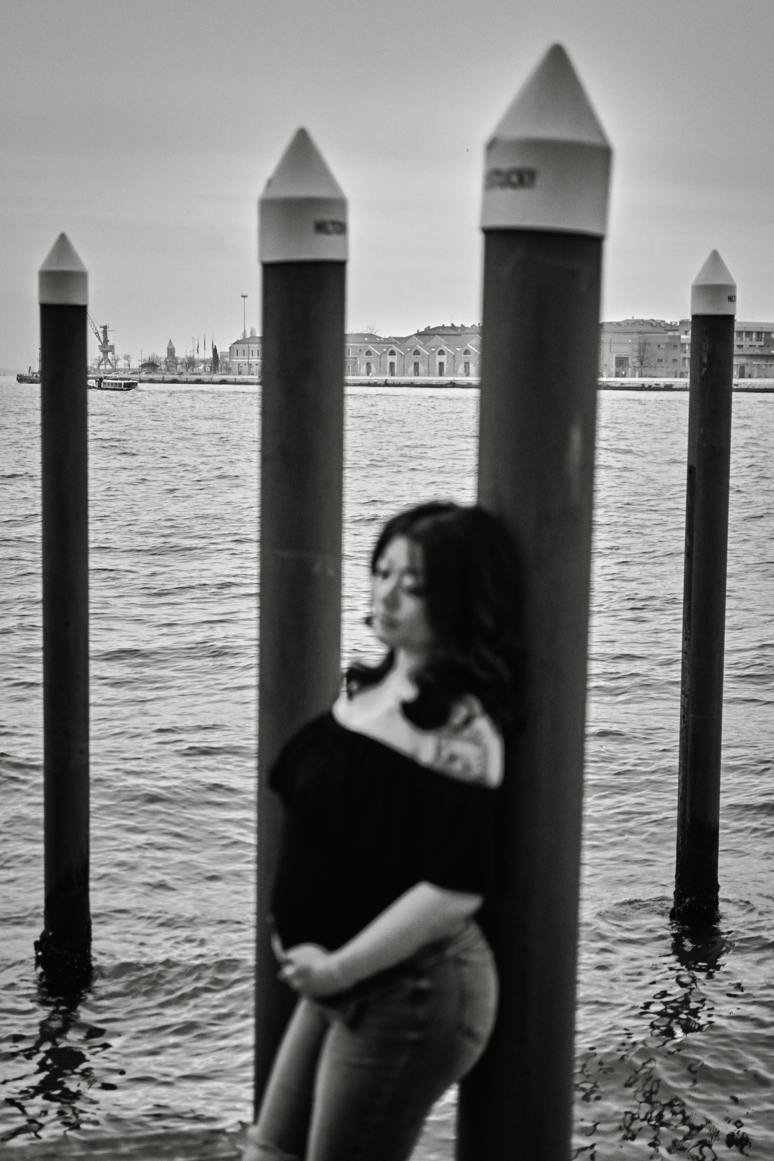 Against a backdrop of crumbling brick walls and ivy-covered archways, a pregnant woman stands in a Venetian alleyway, her flowing dress and loose hair caught in a gentle breeze. The city's timeless beauty echoes the anticipation of new life.