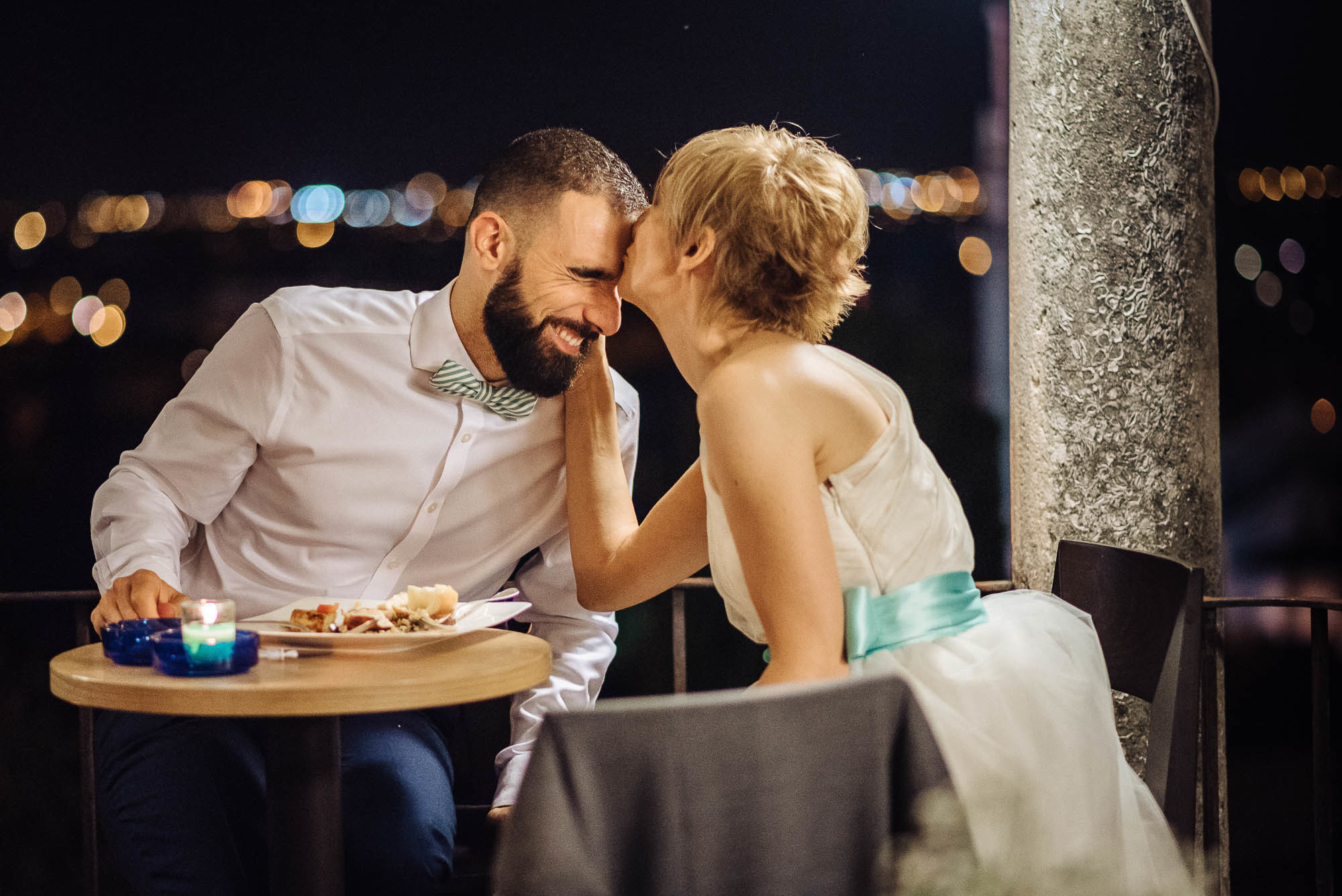 Невеста целует жениха за столиком, свадебная фотосессия в Вероне, Италия