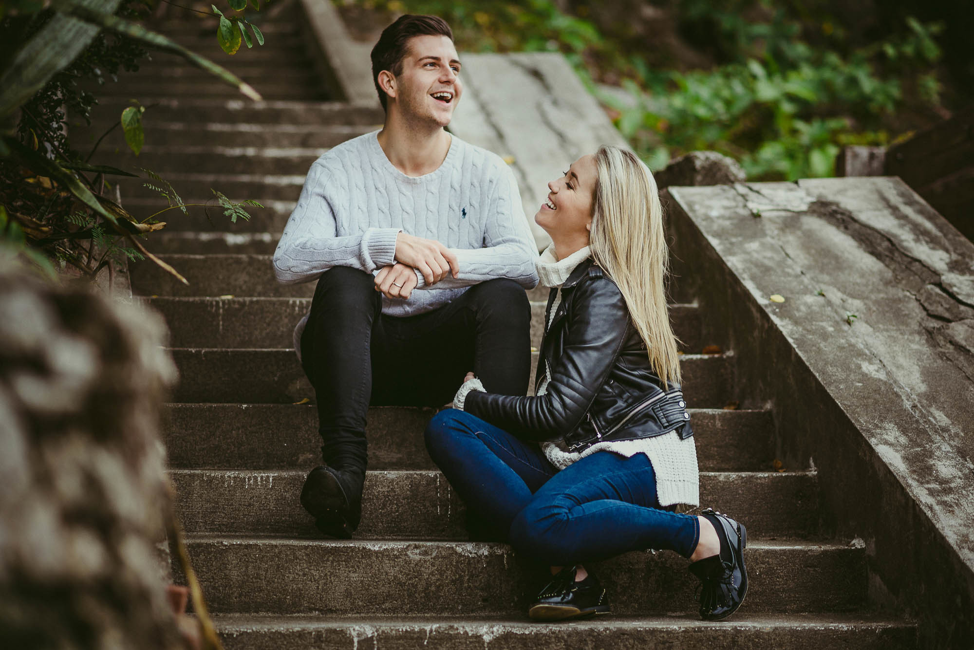 Счастливые влюбленные сидят на ступенях лестницы