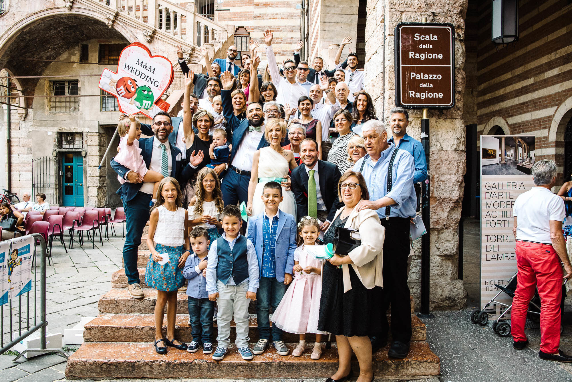 Молодожены и гости на лестнице Дворца бракосочетний в Вероне, Италия