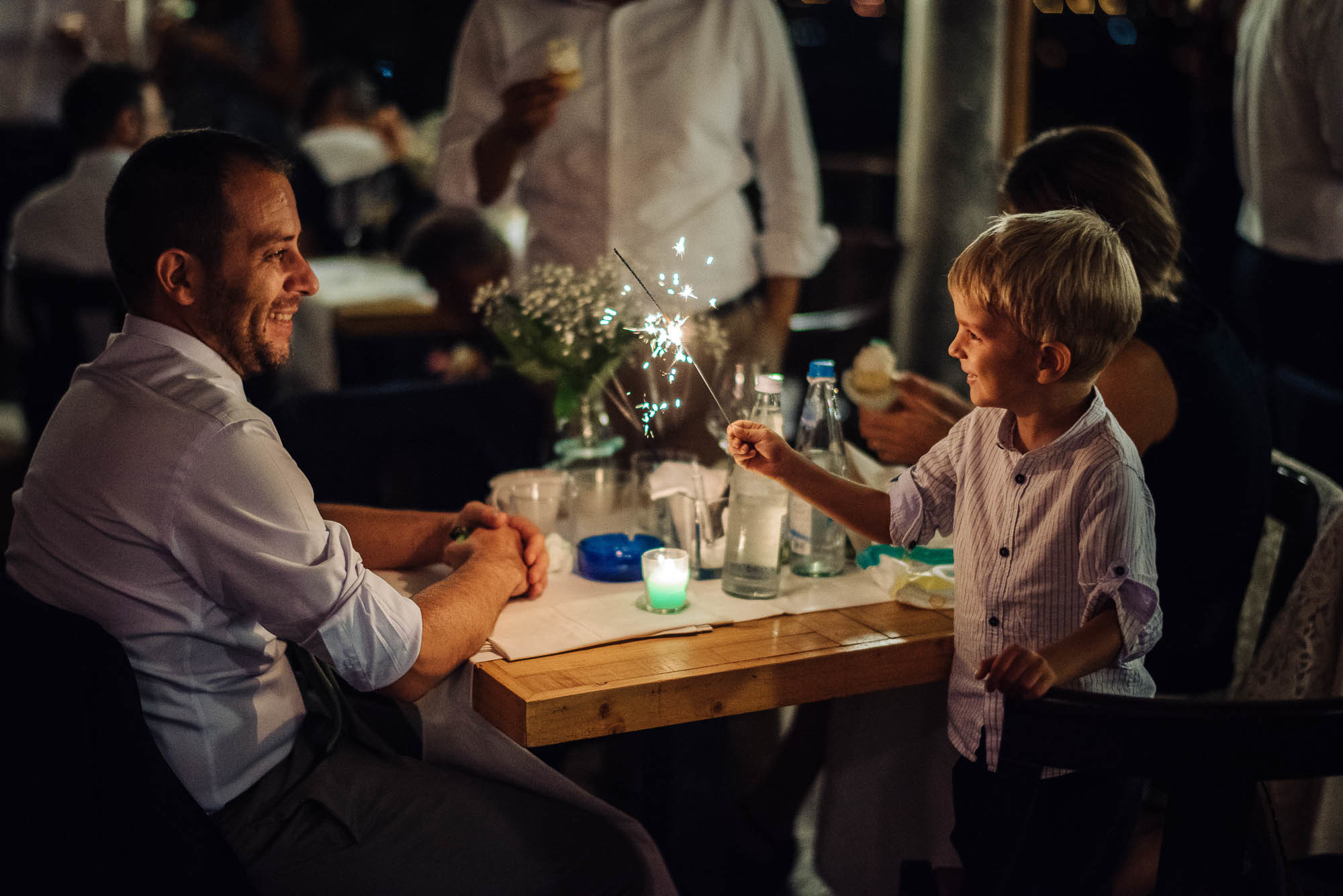 Мальчик держит горящую с искрами бенгальскую палочку