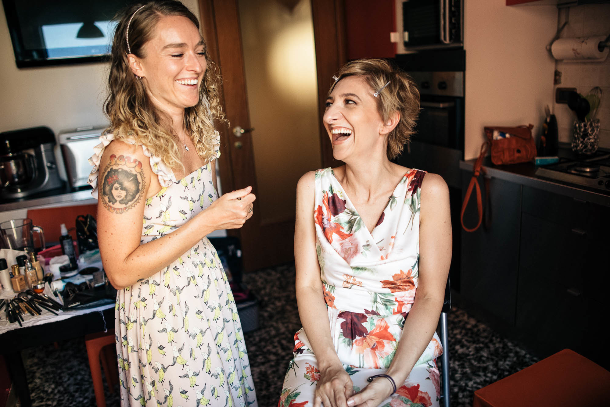 Две девушки в летних платьях в комнате общаются и смеются, фотосессия в Вероне, Италия