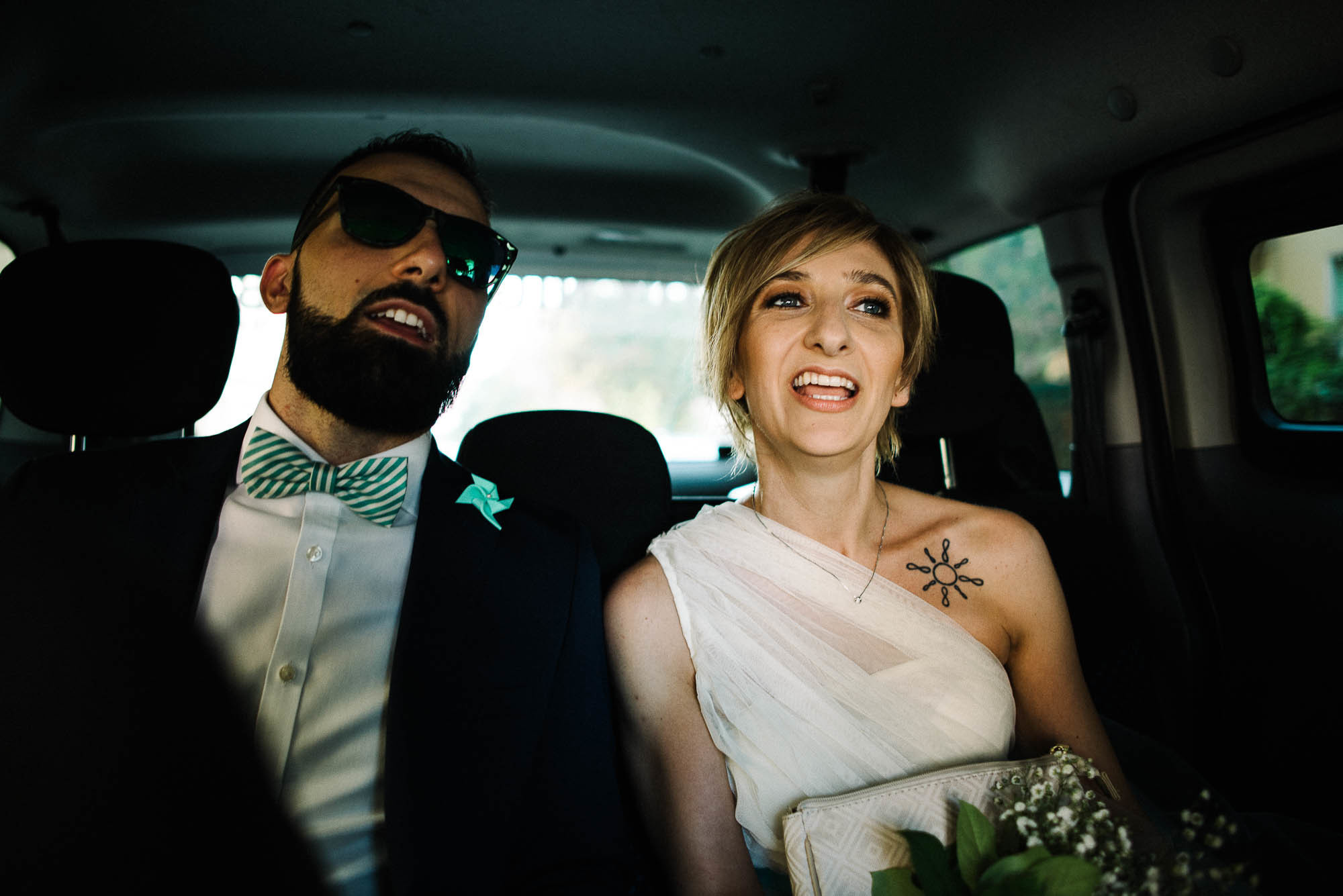 Жених и невеста на заднем сидении автомобиля, свадебная фотосессия в Вероне, Италия
