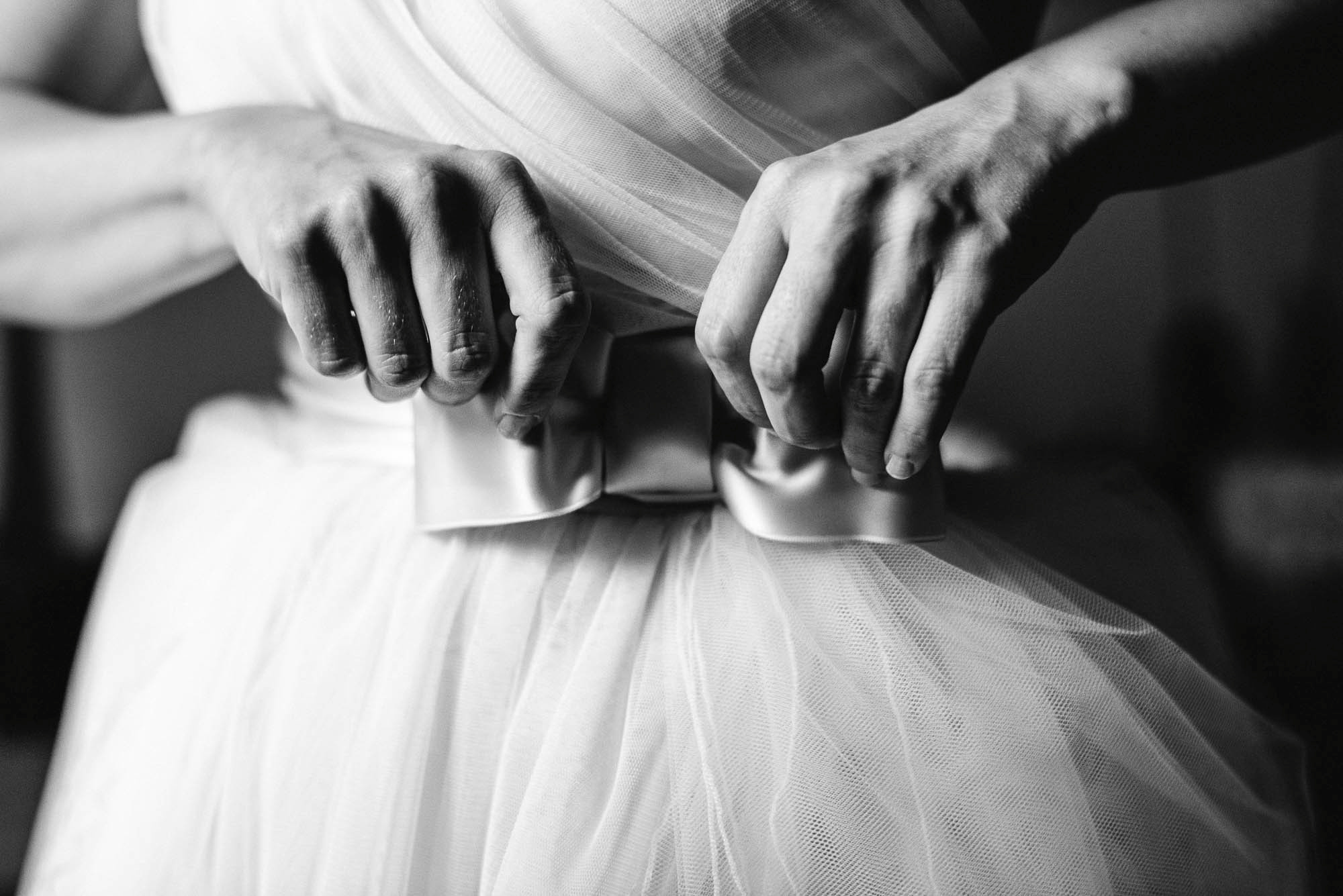 Крупный план, руки поправляют ленту на свадебном платье, черно-белое фото, свадебный фотограф Sergyphoto
