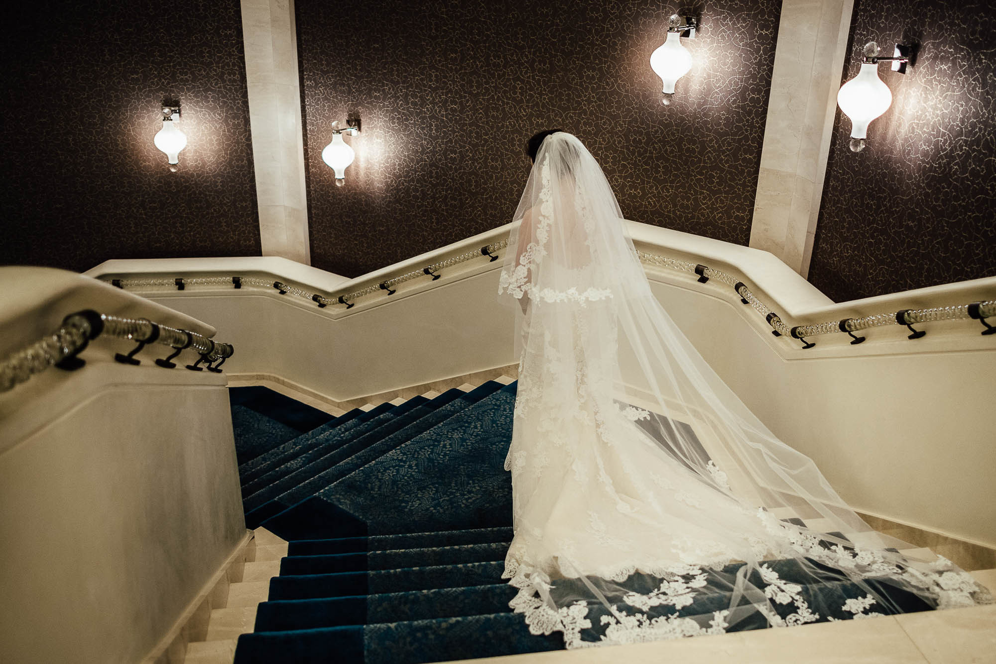 Невеста в белом свадебном платье спускается по лестнице, свадебная фотосессия в Дубаи
