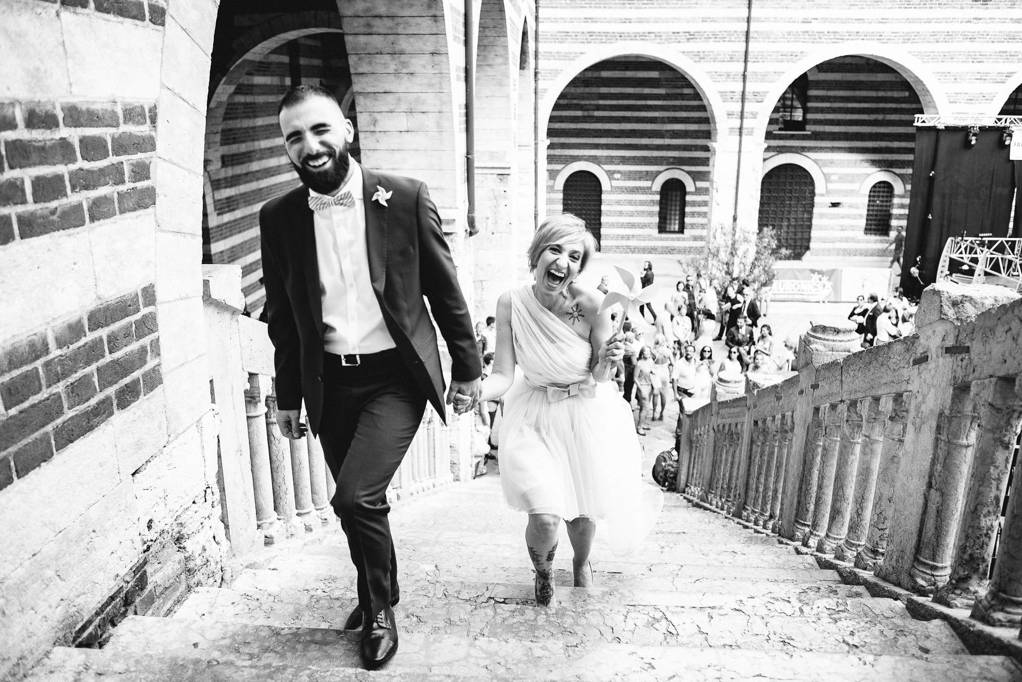 Жених и невеста поднимаются по лестнице на церемонию бракосочетния, свадебный фотограф в Вероне, Италия