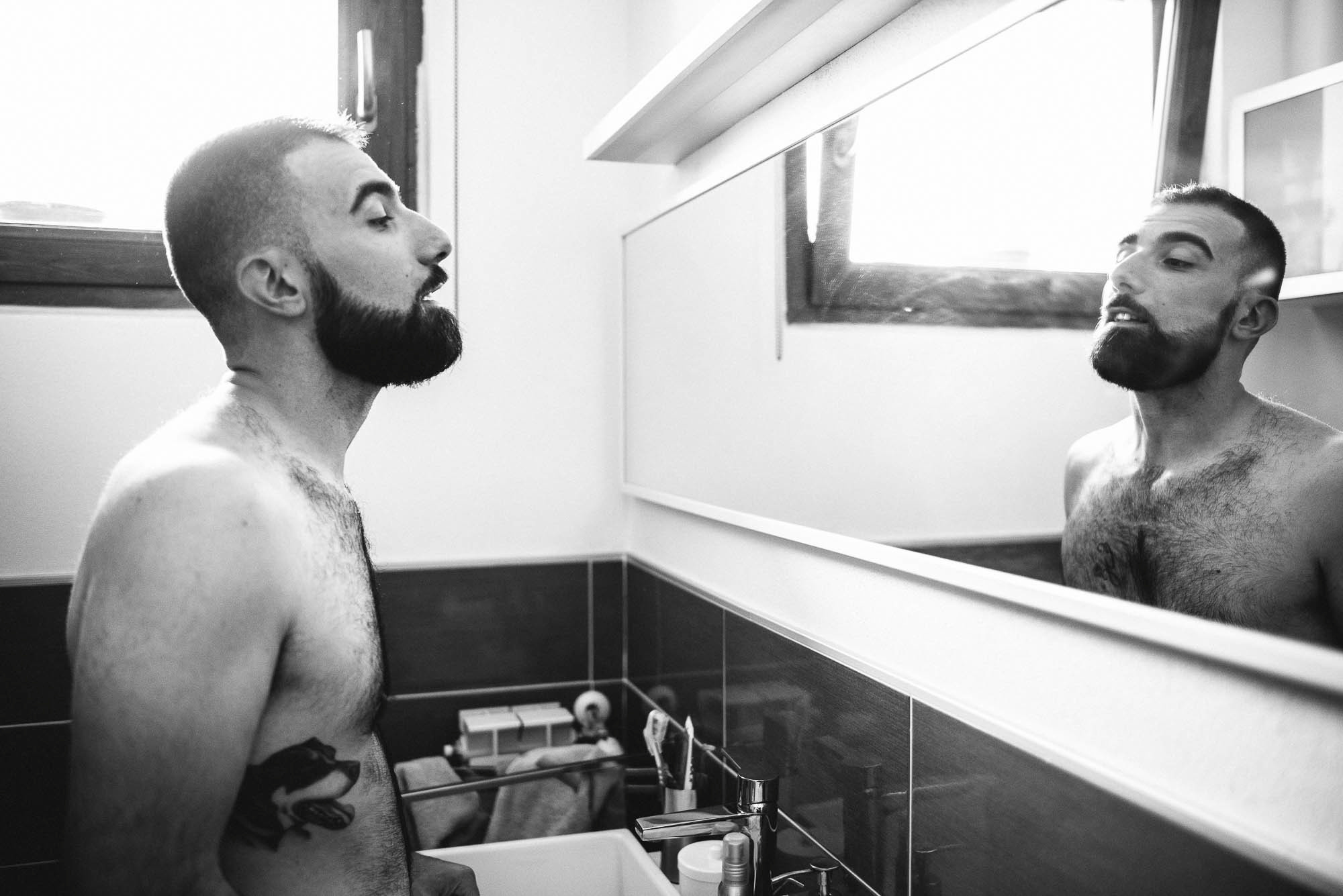 Мужчина с бородой у зеркала в ванной ,свадебная фотосессия в Италии