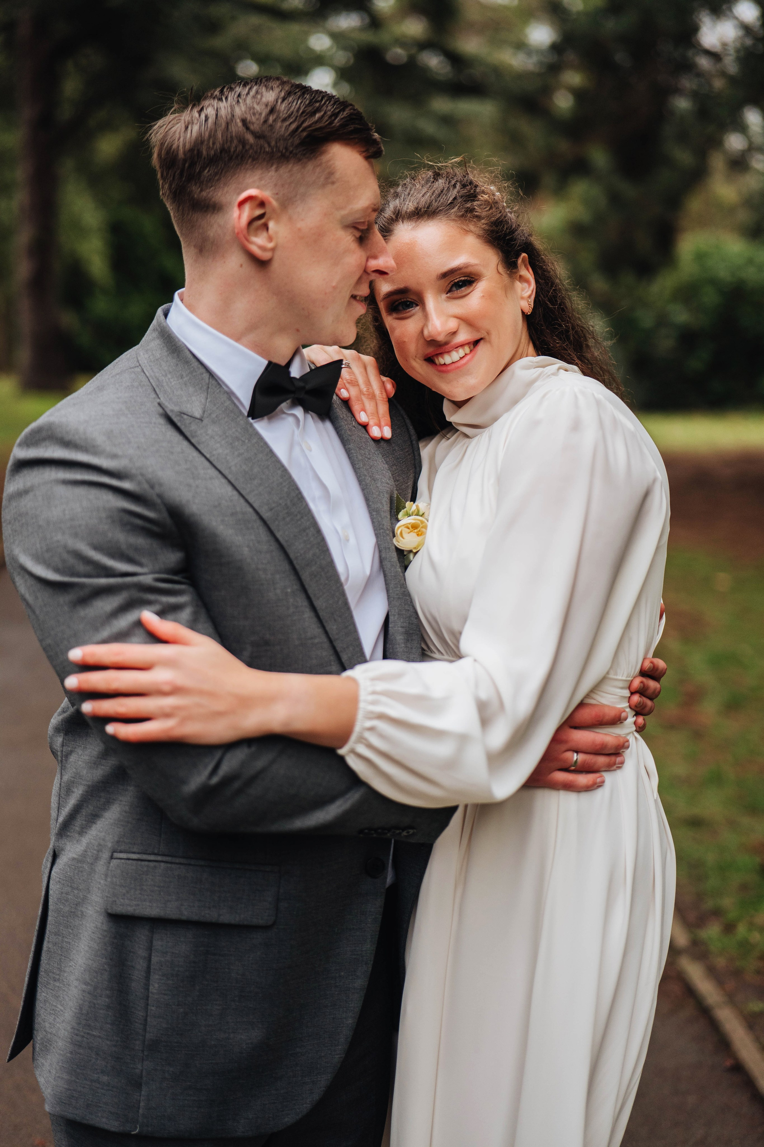 groom and bride walking down the path in the park and hugging