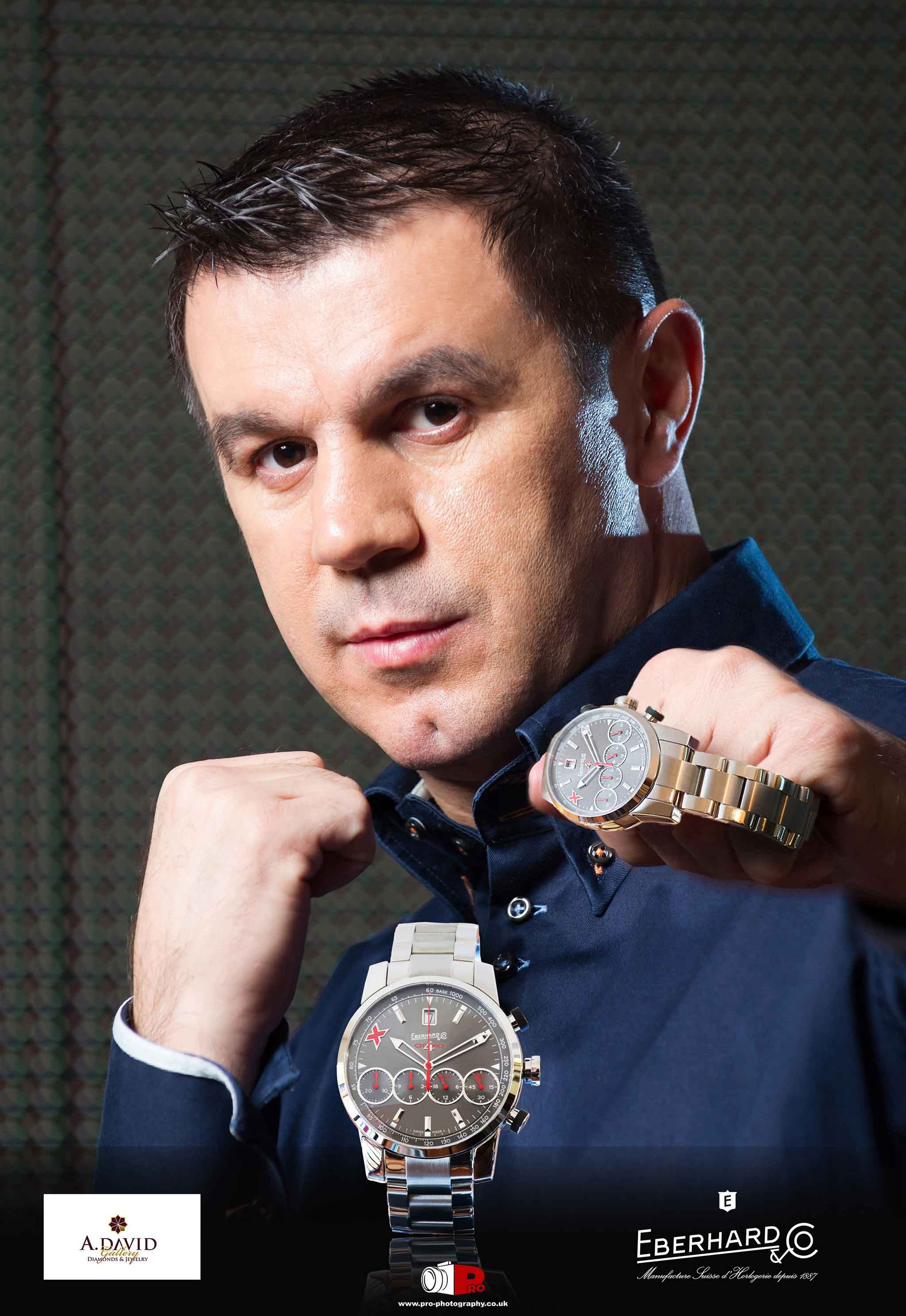 Man posing with Eberhard & Co. luxury wristwatches for an advertisement.
