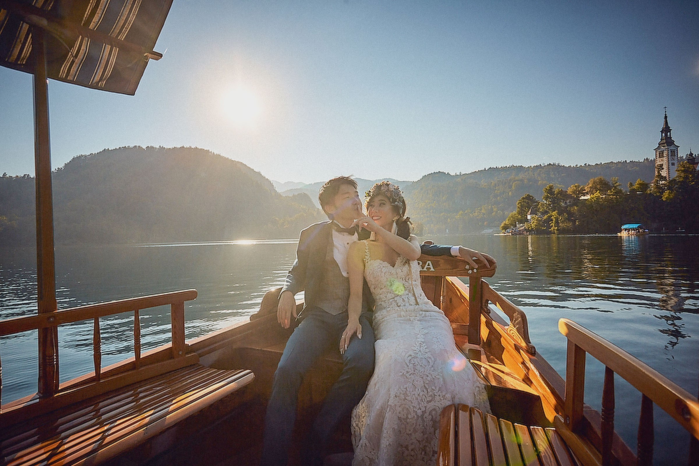 Romantic scene of a Japanese bride and groom basking in the warm glow of the early evening sun on a boat.