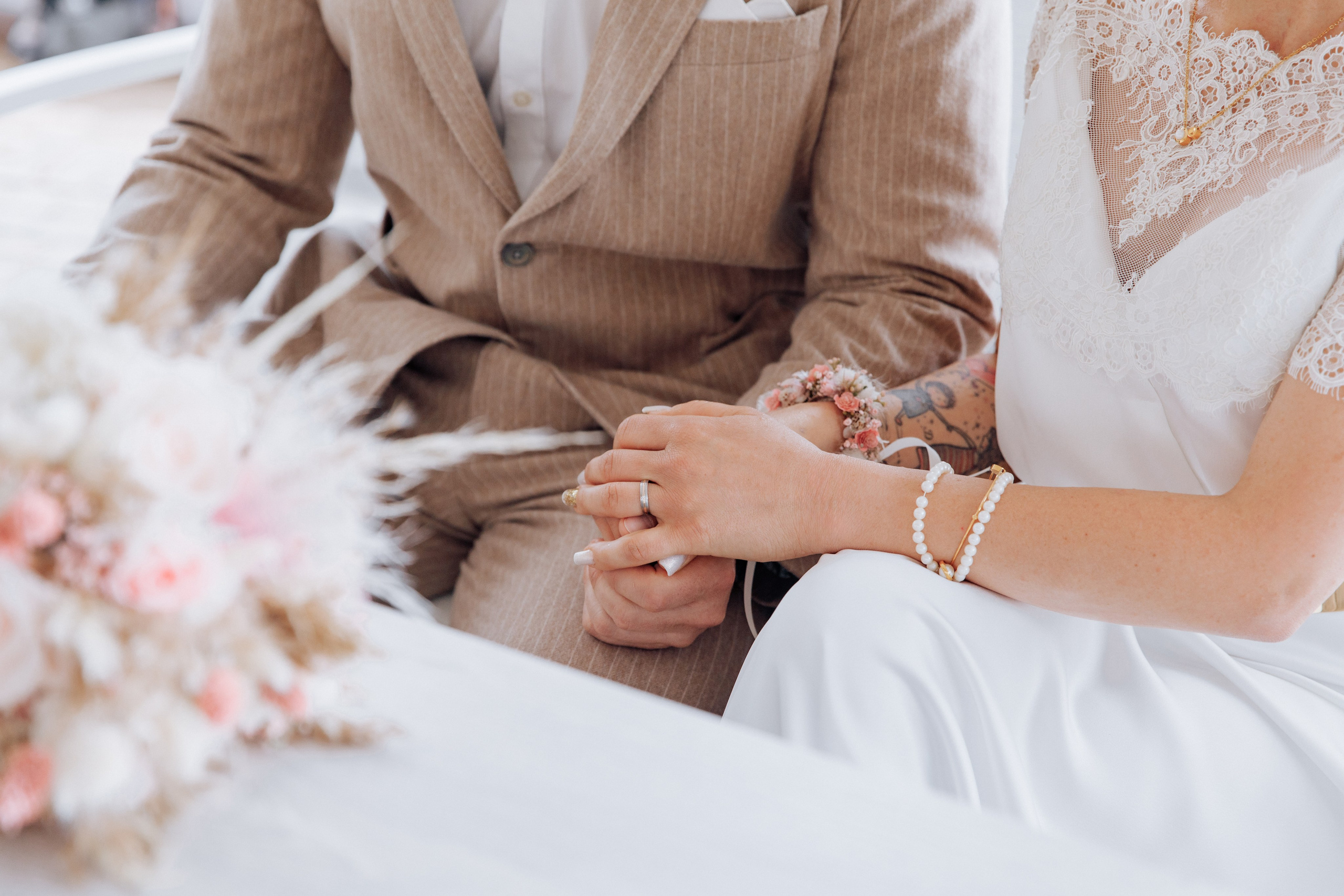 Die Braut hält während der freien Trauung zärtlich die Hand des Bräutigams.