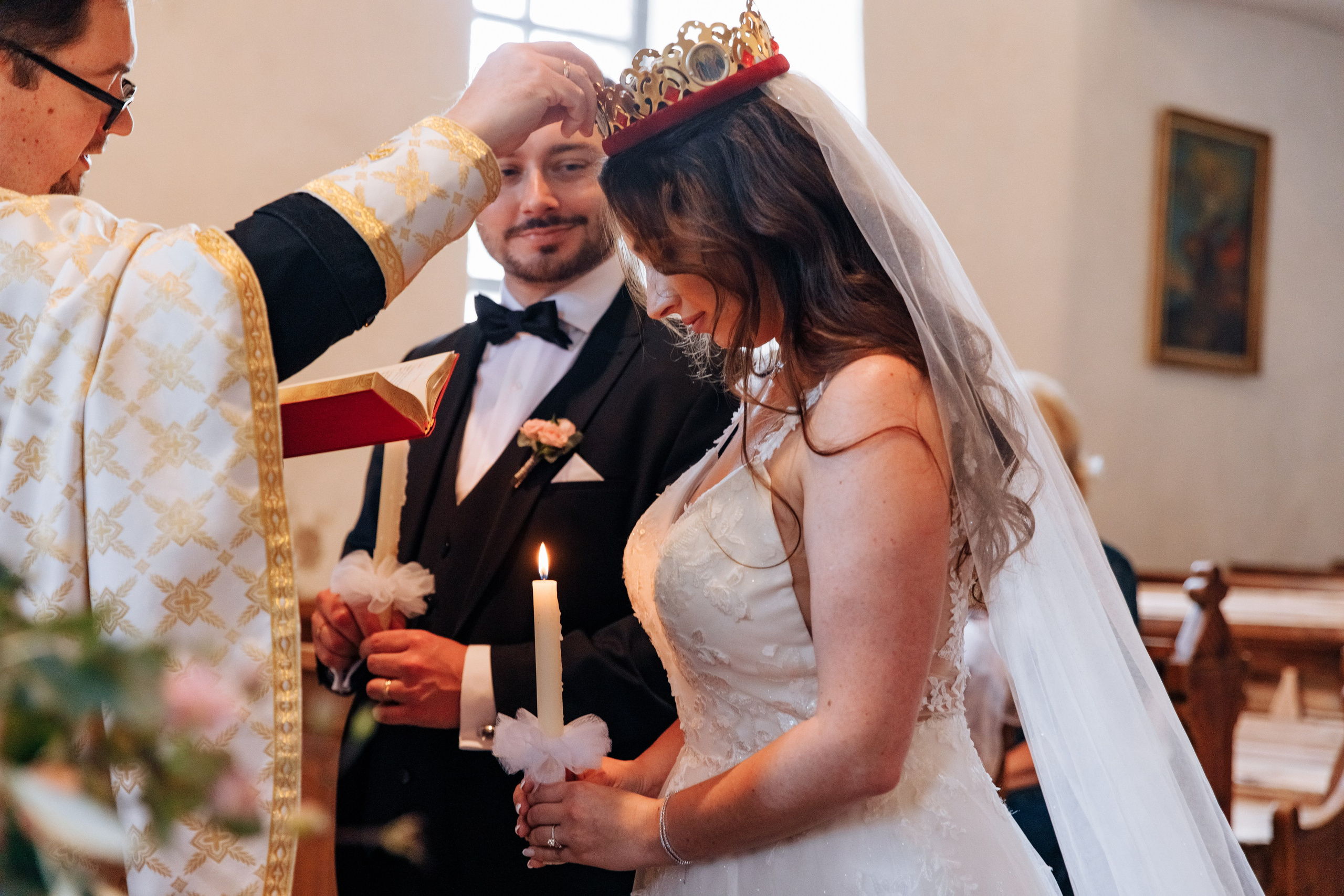 Der Priester setzt der Braut die Krone auf und betet während der Hochzeitszeremonie.