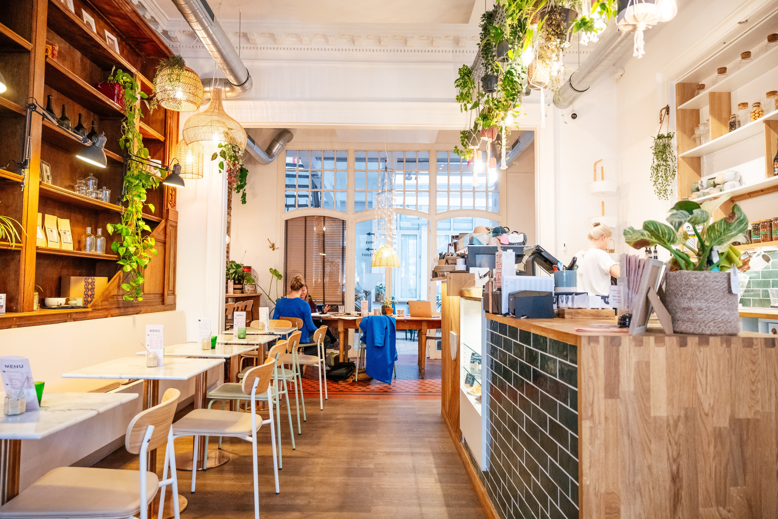 Moment artistic surprins într-o cafenea boemă, lumină ambientală caldă, branding vizual pentru localuri premium