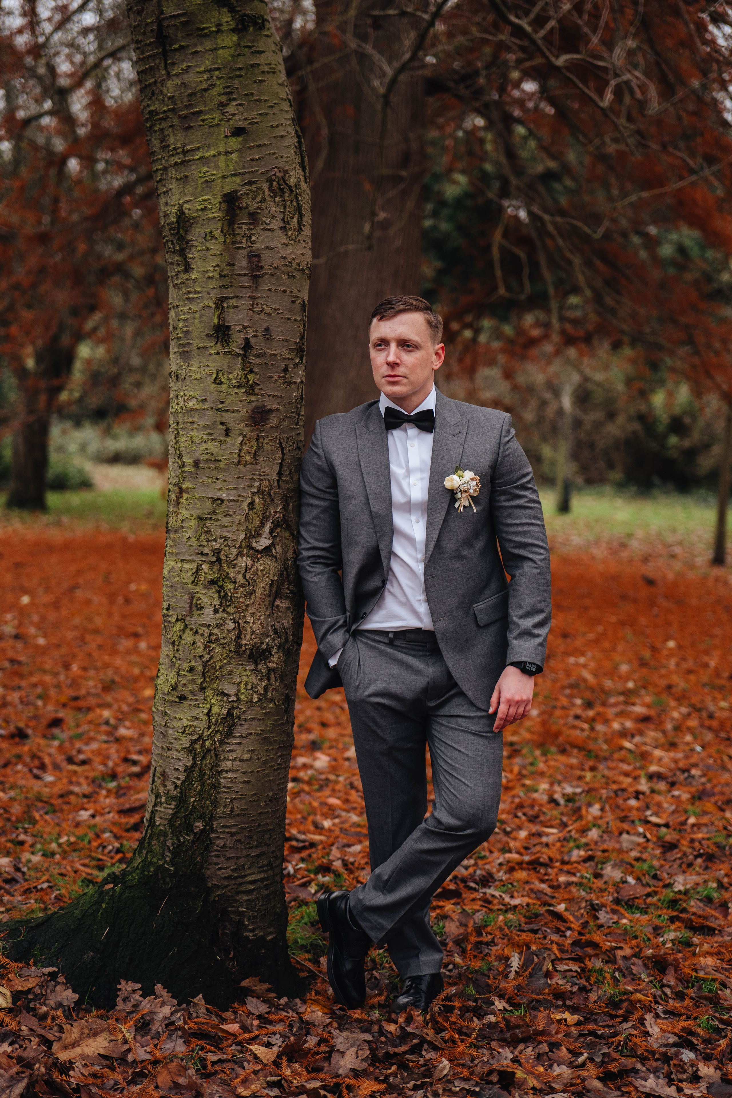 Handsome groom in autumn park in London