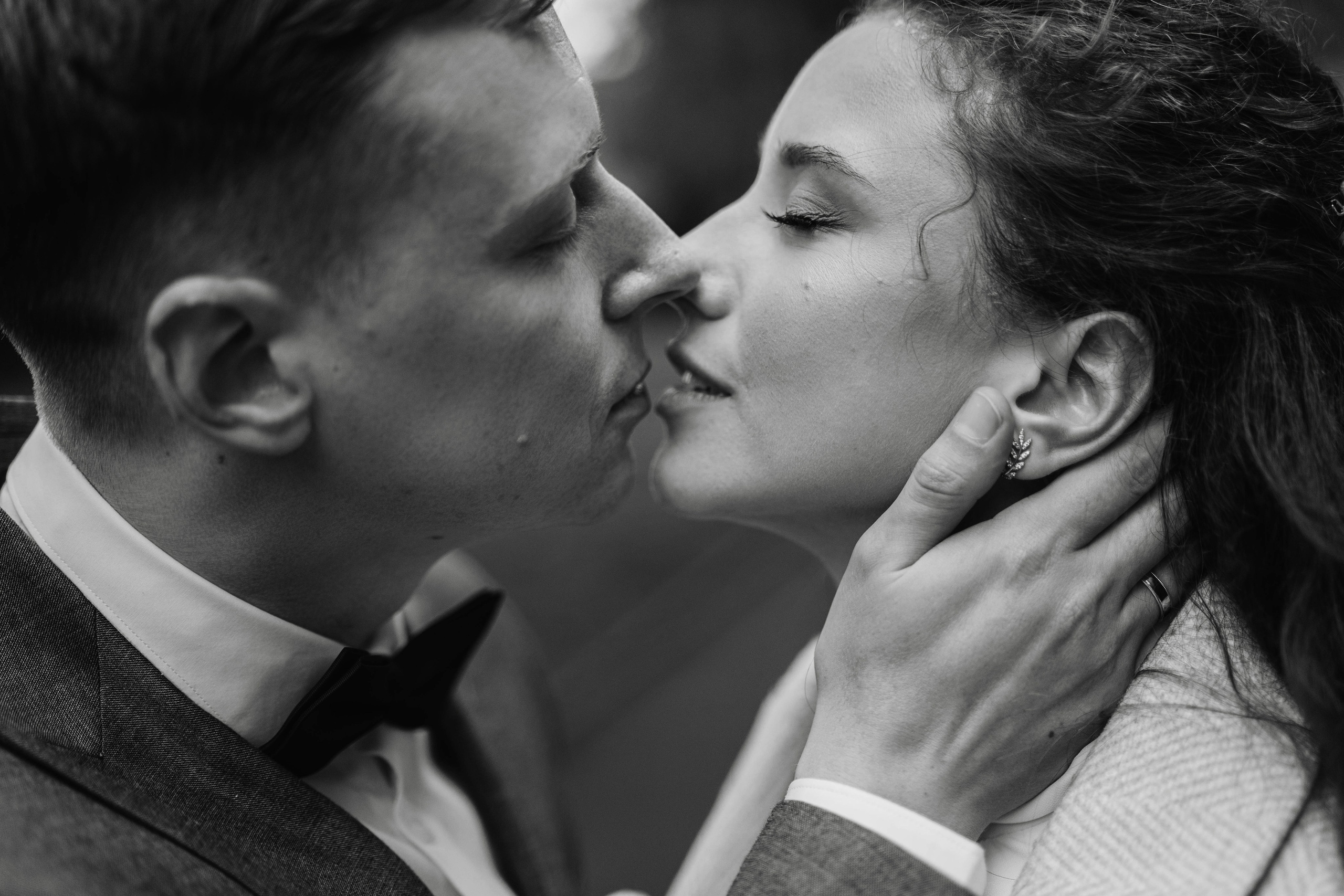 groom and bride kissing on path in the park, closeup