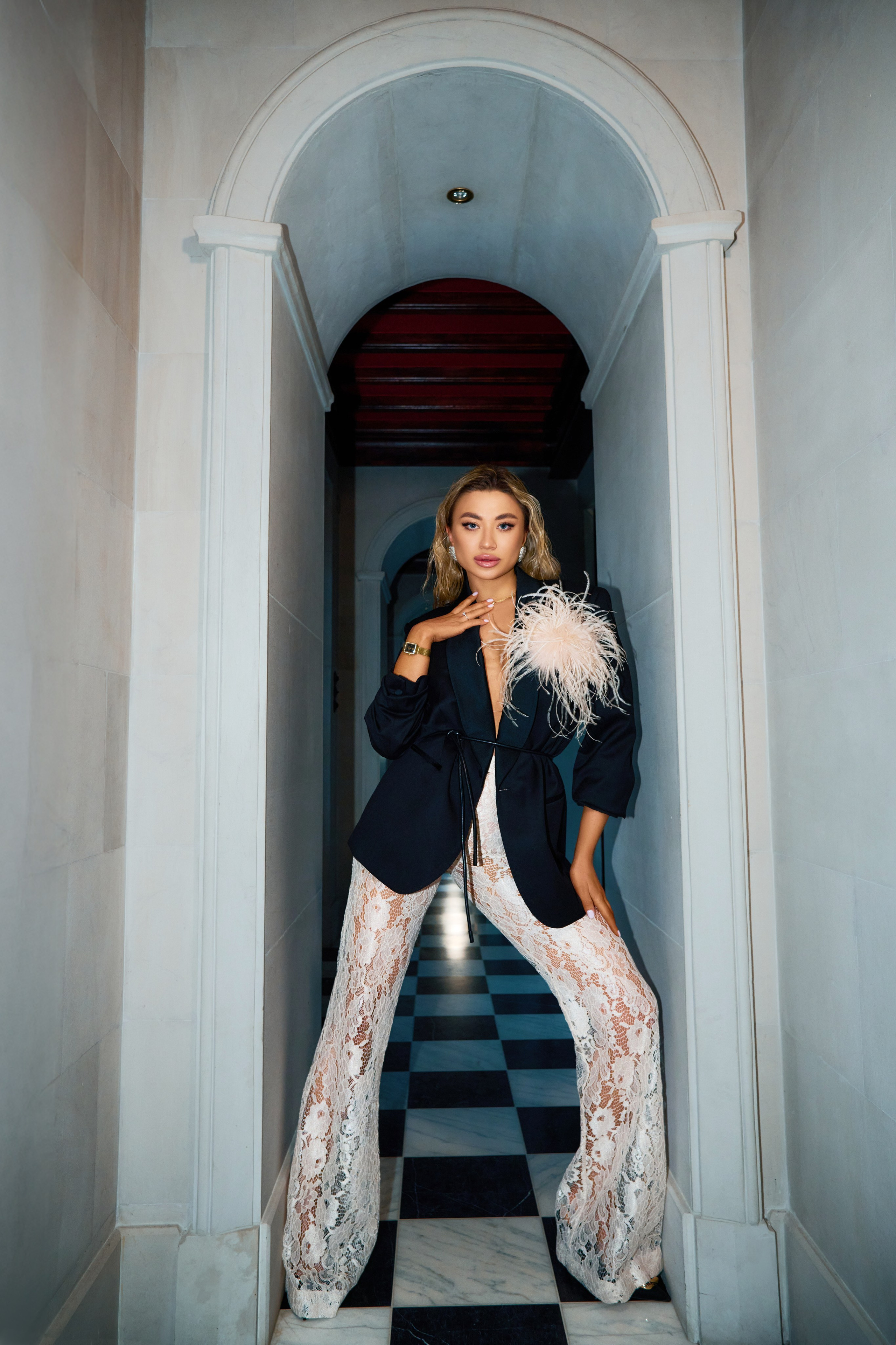 Fashion shoot of woman in chic outfit in opulent mansion living room