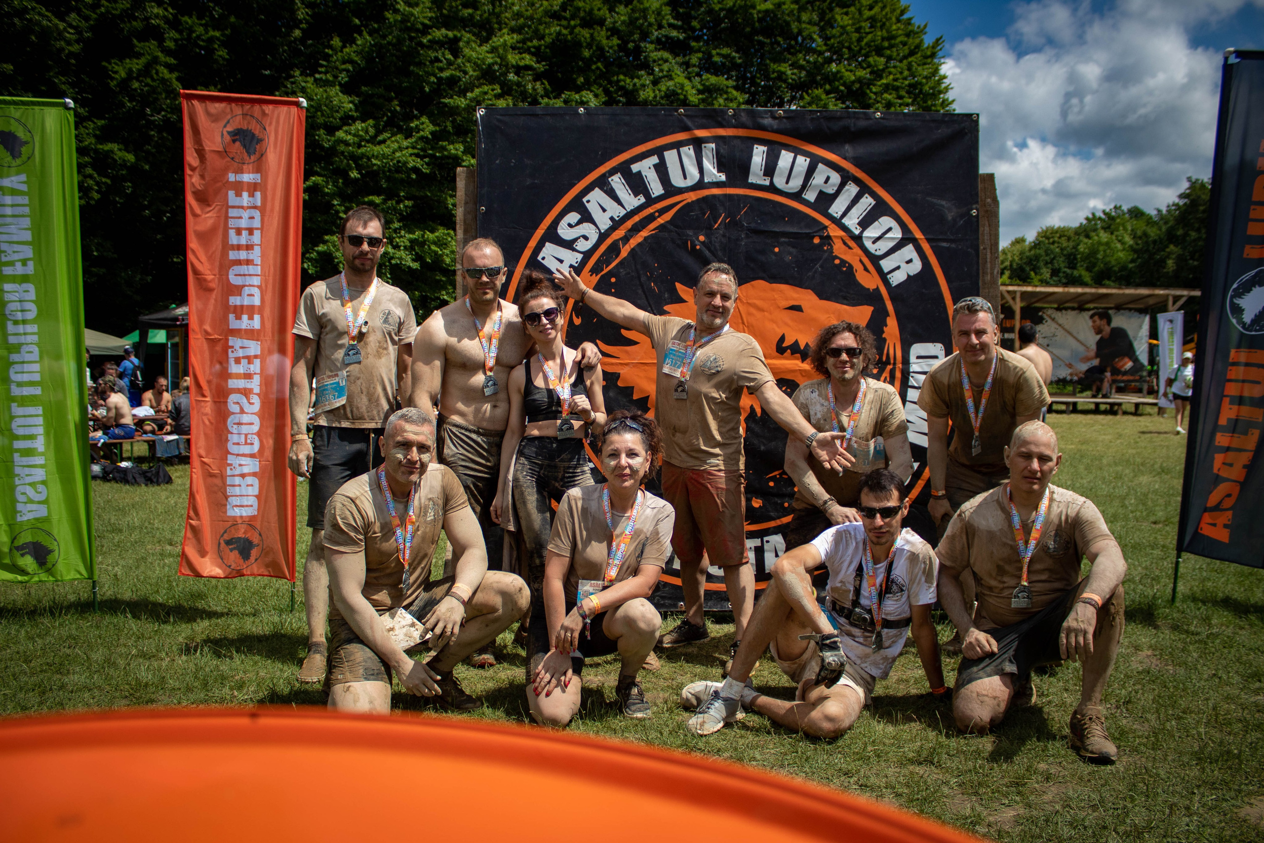 Athletes posing at the finish line of a mud run or obstacle race event.