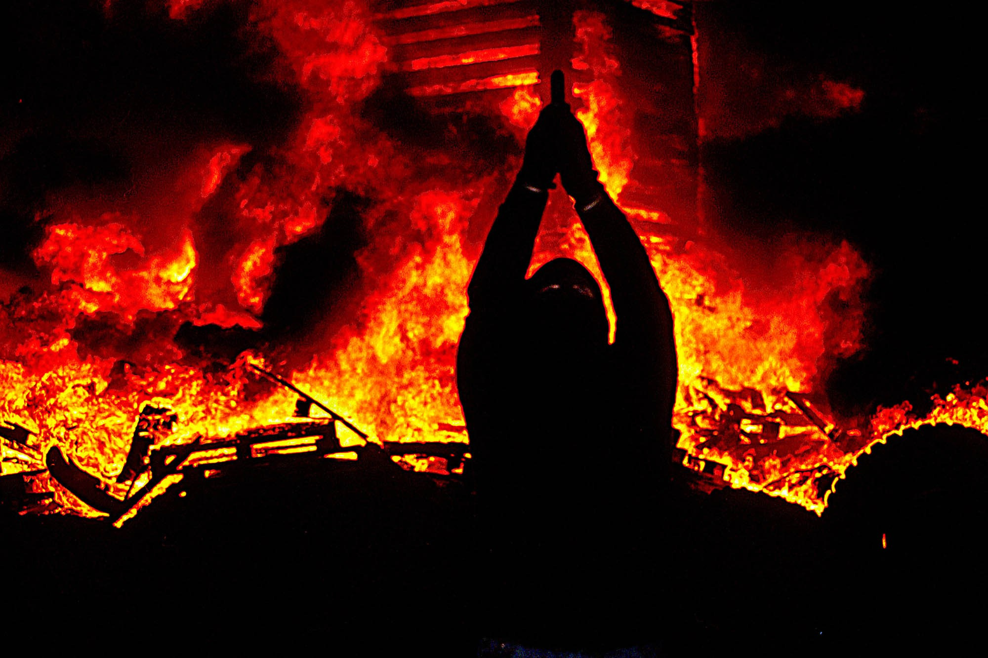 An Ulster Freedom Fighter (UFF) discharges his firearm in front of a two-story fire in Belfast's Sandy Hill neighborhood in celebration of the July 11, aka the "Eleventh Night" a major Protestant loyalist celebration in Northern Ireland. The celebration marks the beginning of the annual marching season that often results in clashes with Irish nationalists and republicans.