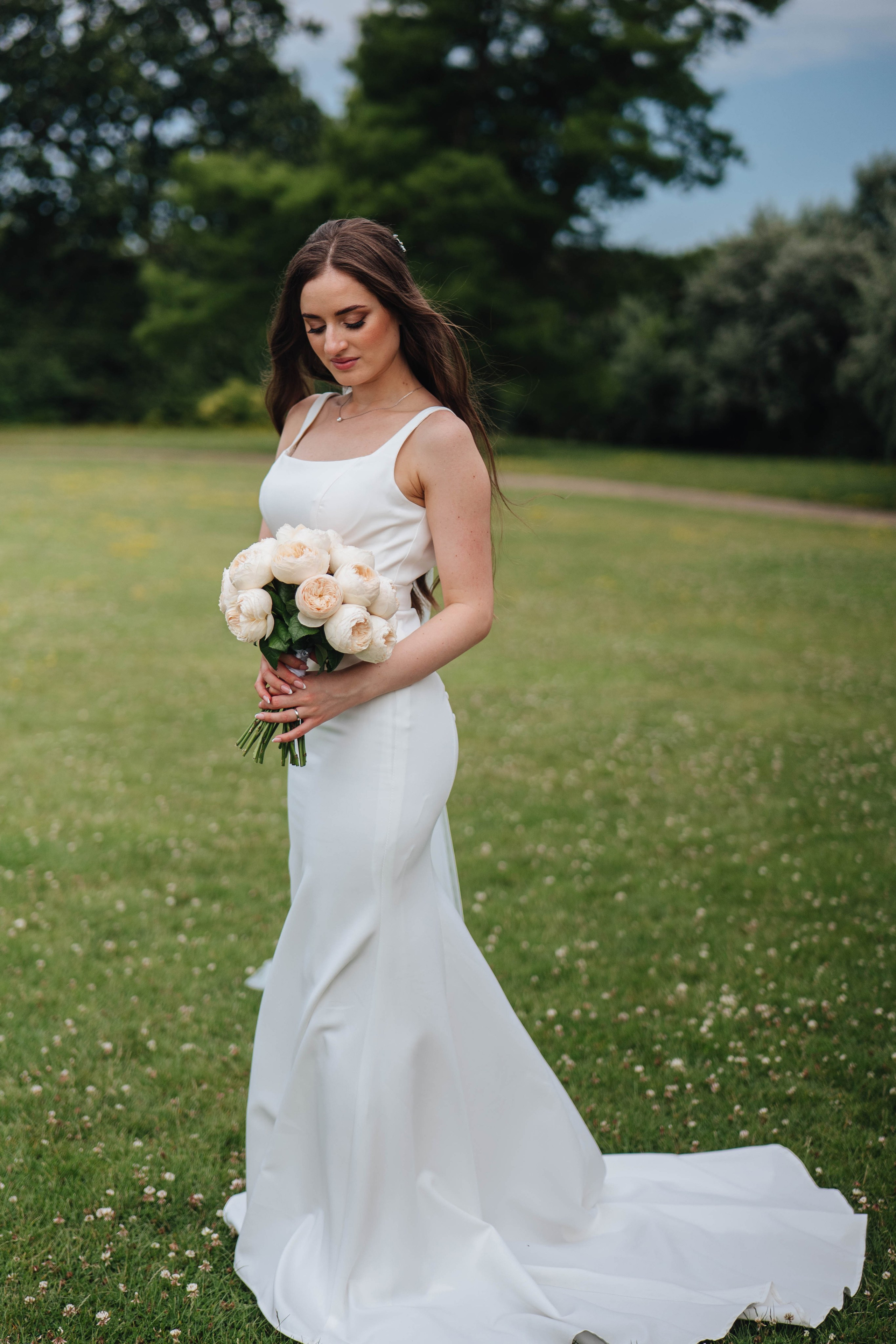 beautiful bride in the summer park with white flowers