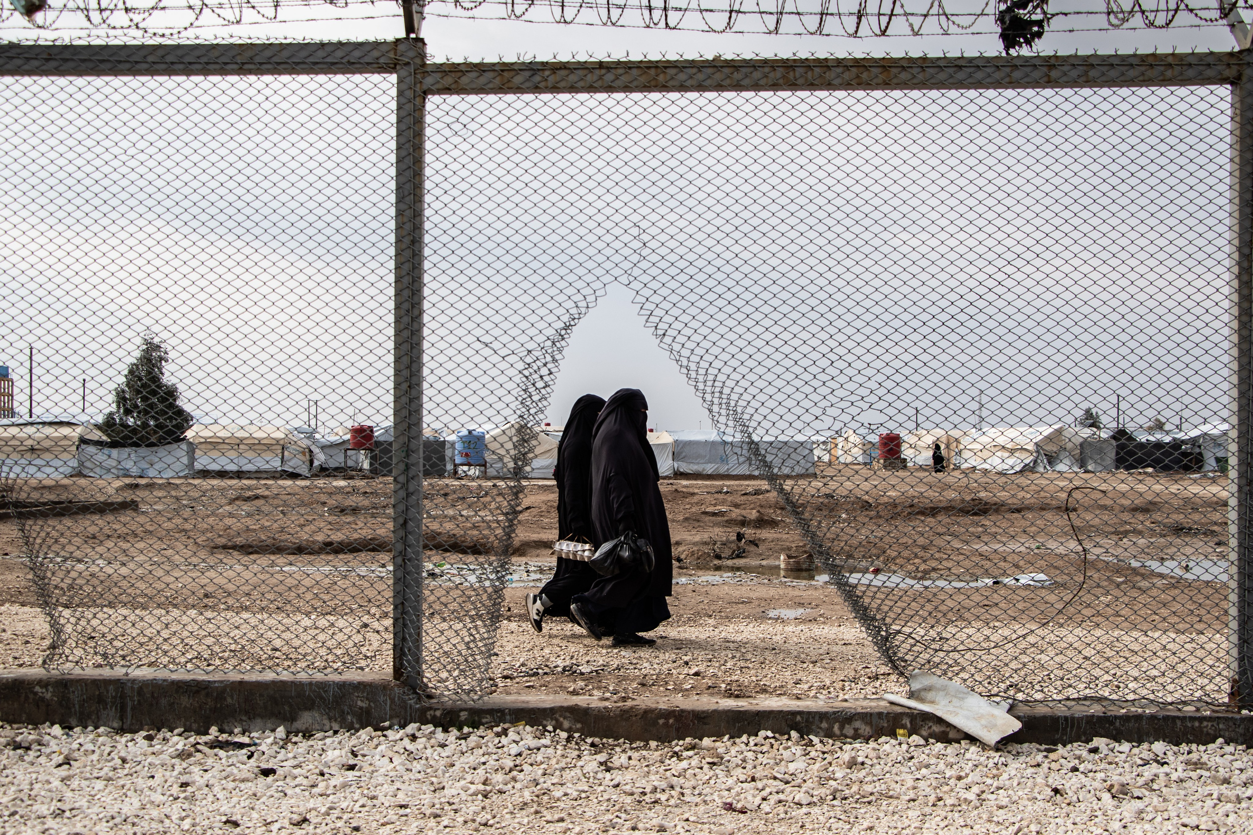 Deux femmes marchent proche des grilles du camps Al-Hol, prisonniers de Daesh, dans le Rojava Kurdistan Syrien.