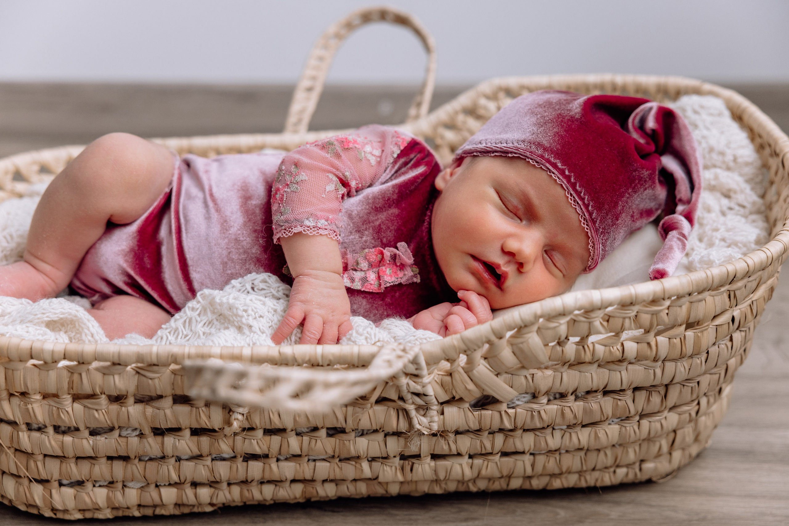 Baby liegt im Korb mit Kuscheldecke – natürliche Newborn-Fotografie München.