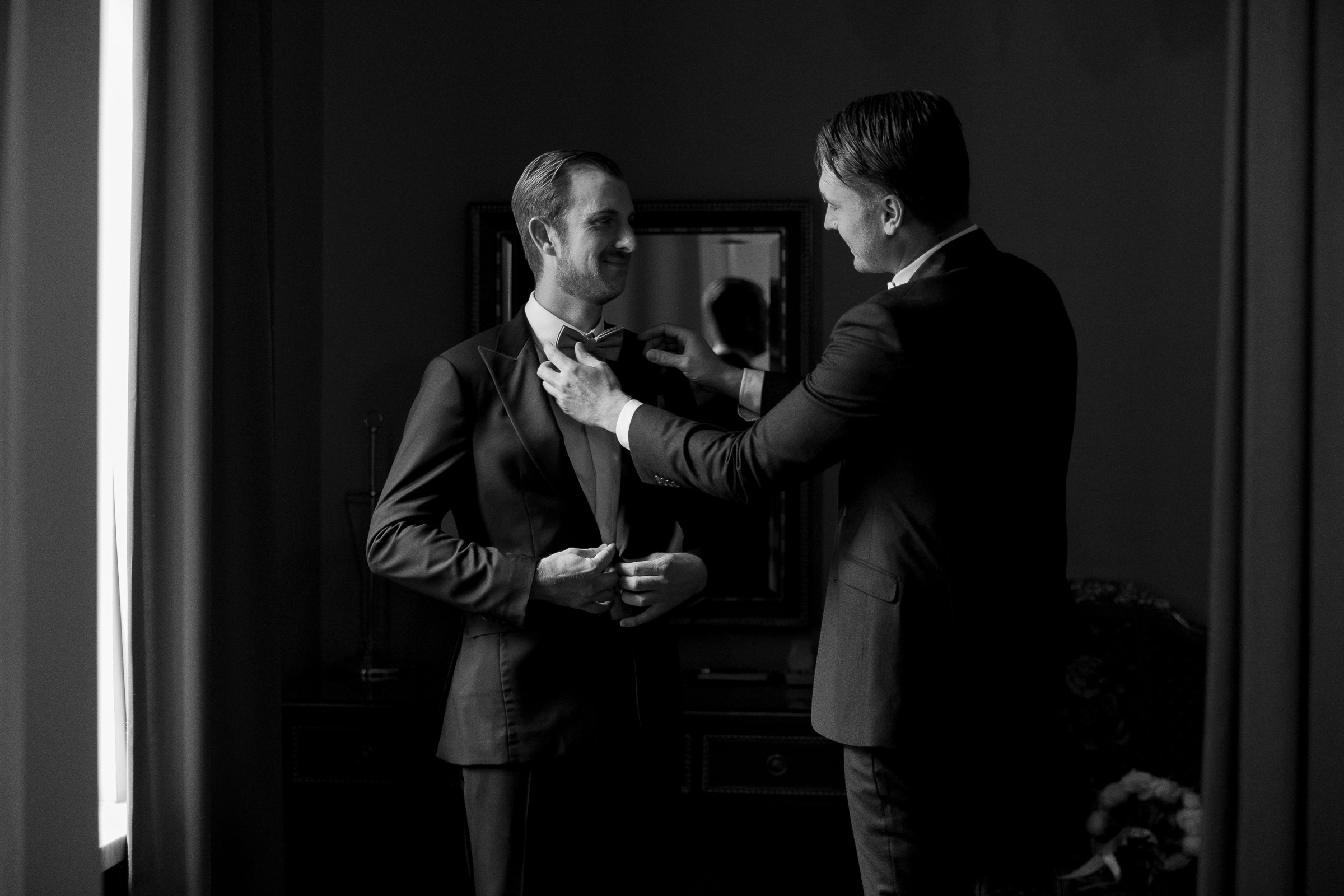 Groomsmen adjusting tie, by Bude wedding photographer.