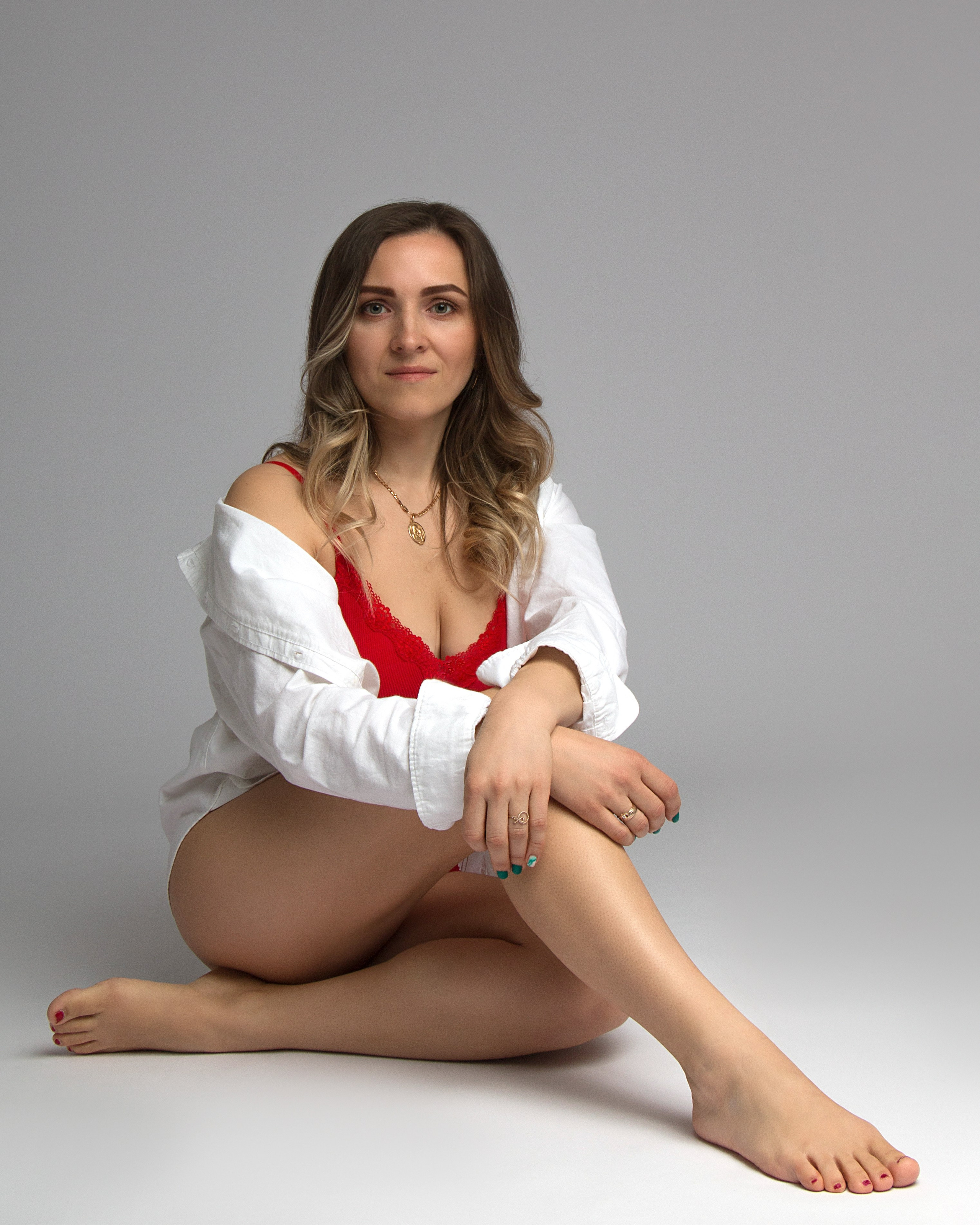 Studiofoto mit elegantem Kontrast – weiße Bluse und rotes Unterwäsche-Set