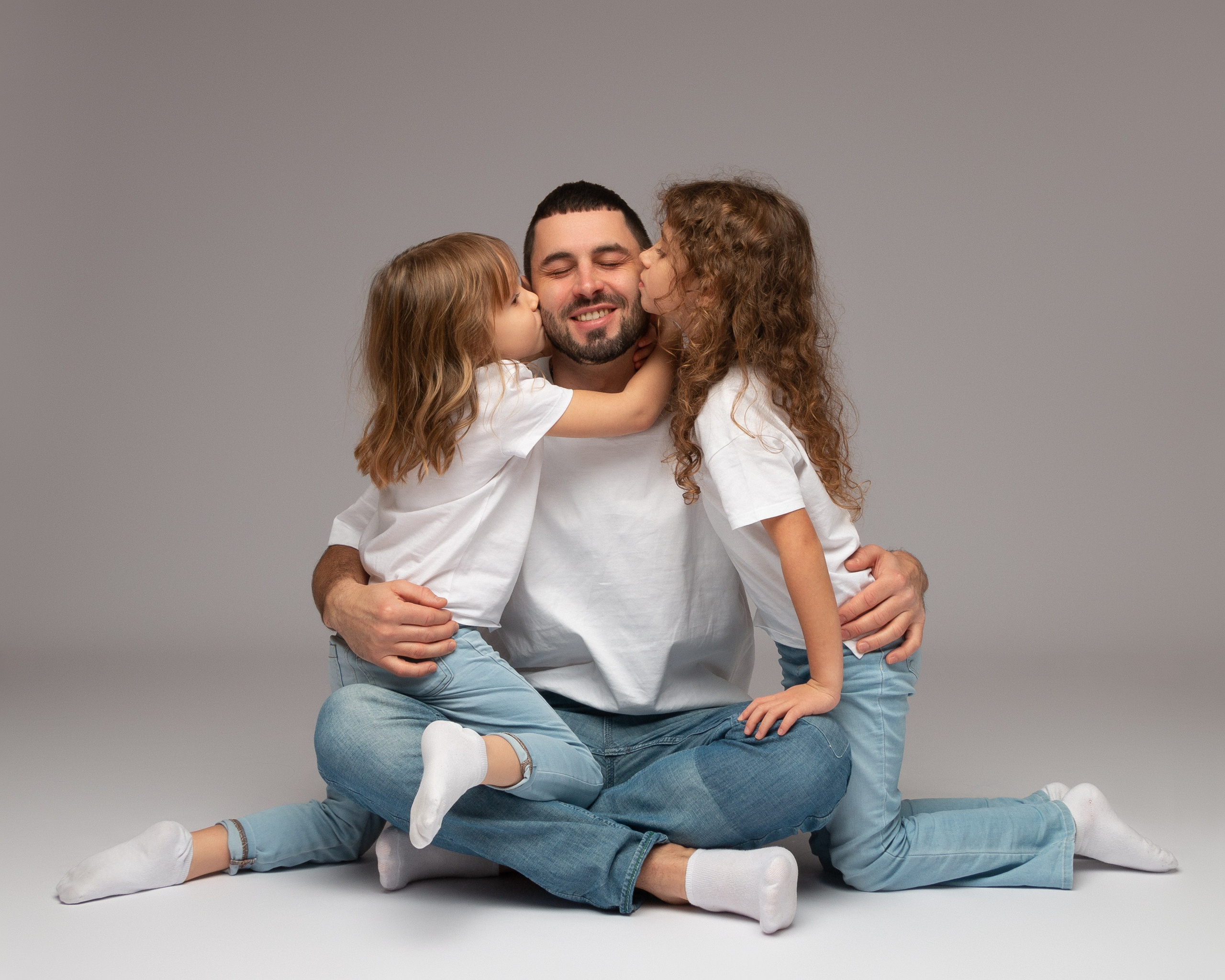 Papa mit seinen beiden Töchtern – fröhlicher Familienmoment voller Nähe