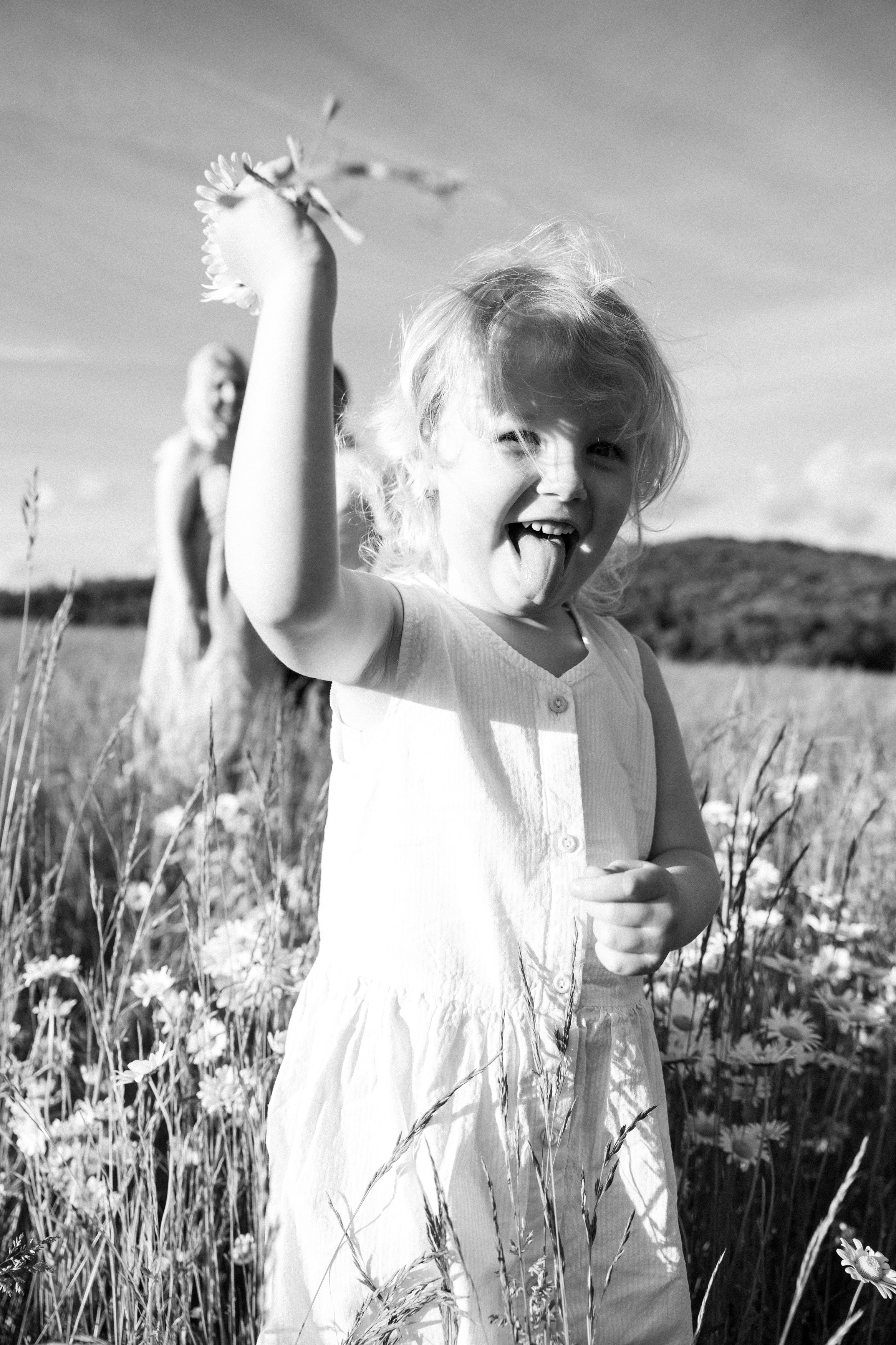 Family photoshoot in a daisy meadow at golden hour — natural light, warm tones, candid moments between a mother and her daughters. Lifestyle and Family Photographer in Pisek Oxana Telupilova