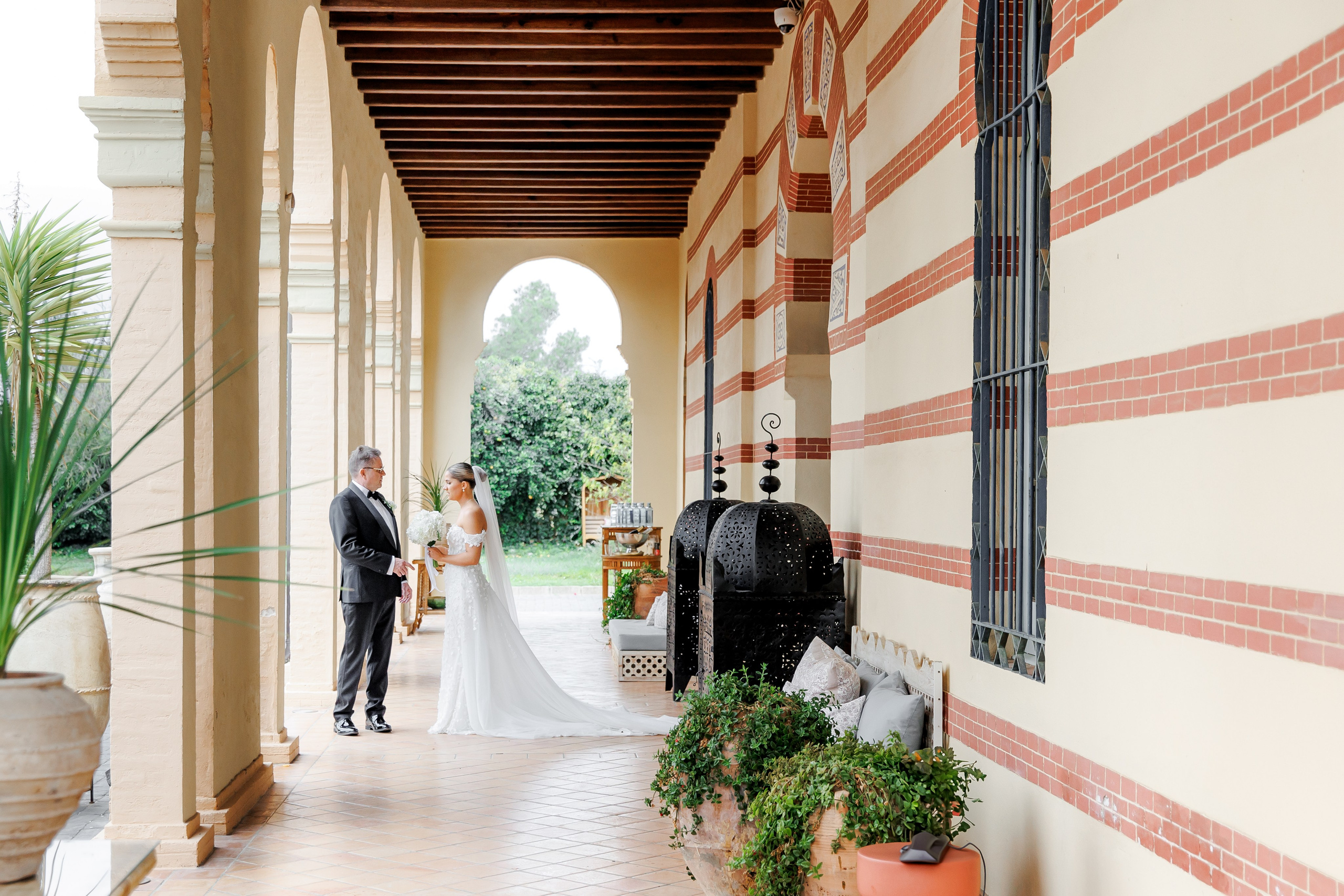 Intimate moment: father embracing daughter before aisle walk at a Spanish elegant venue.