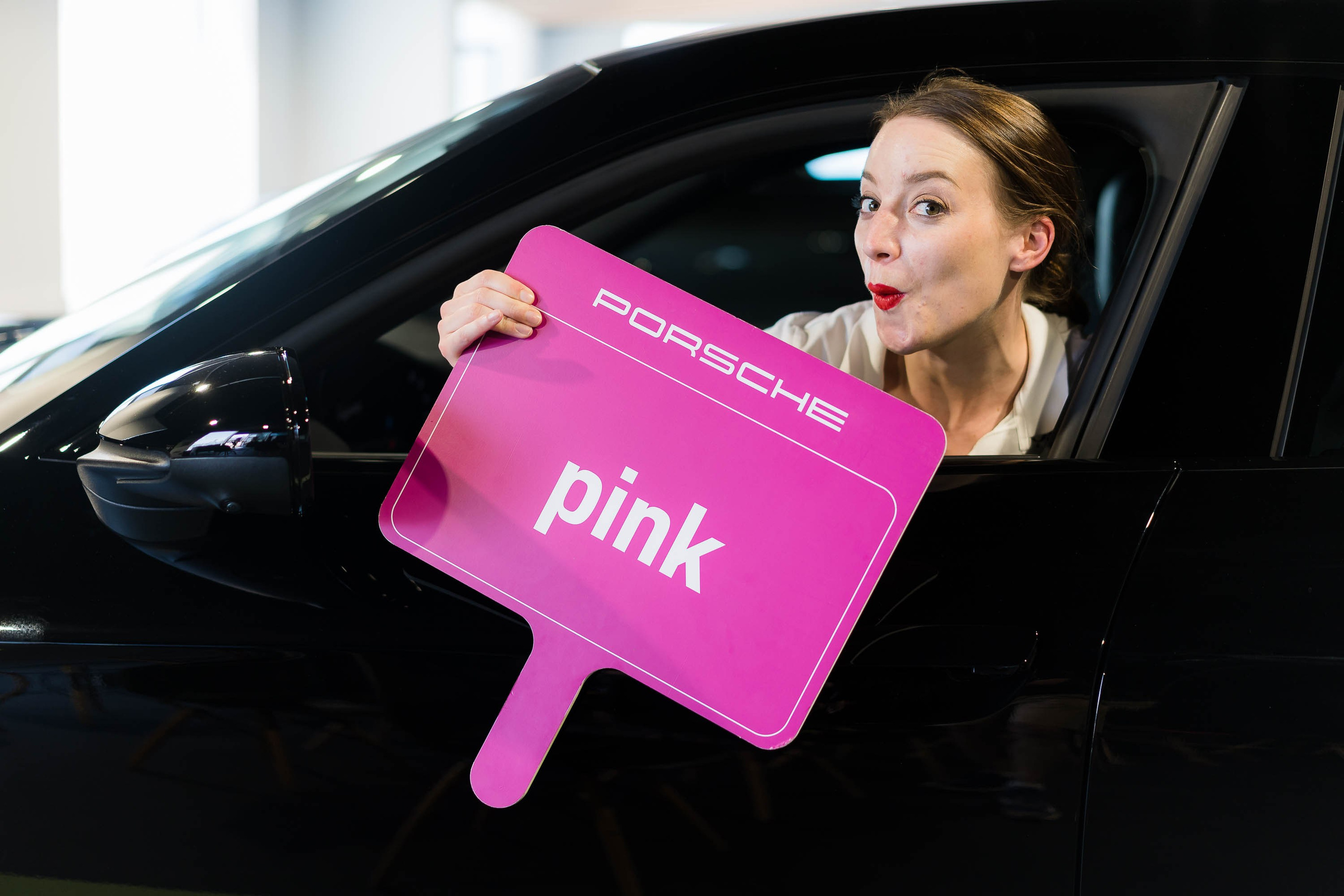 Porsche trainee poses inside a Porsche 911 car