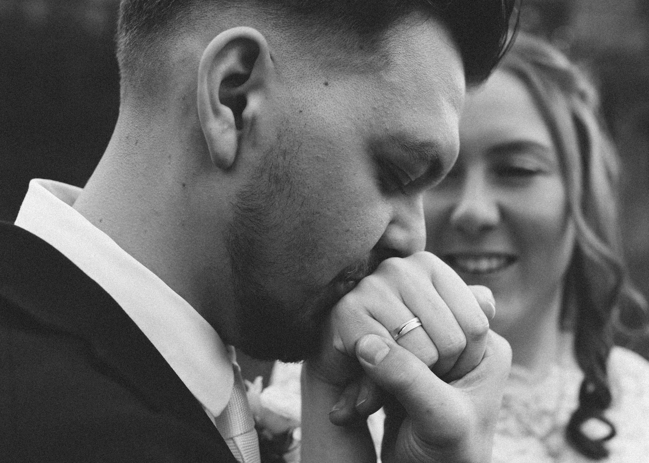 Verliebter Handkuss des Bräutigams an die Hand seiner Braut