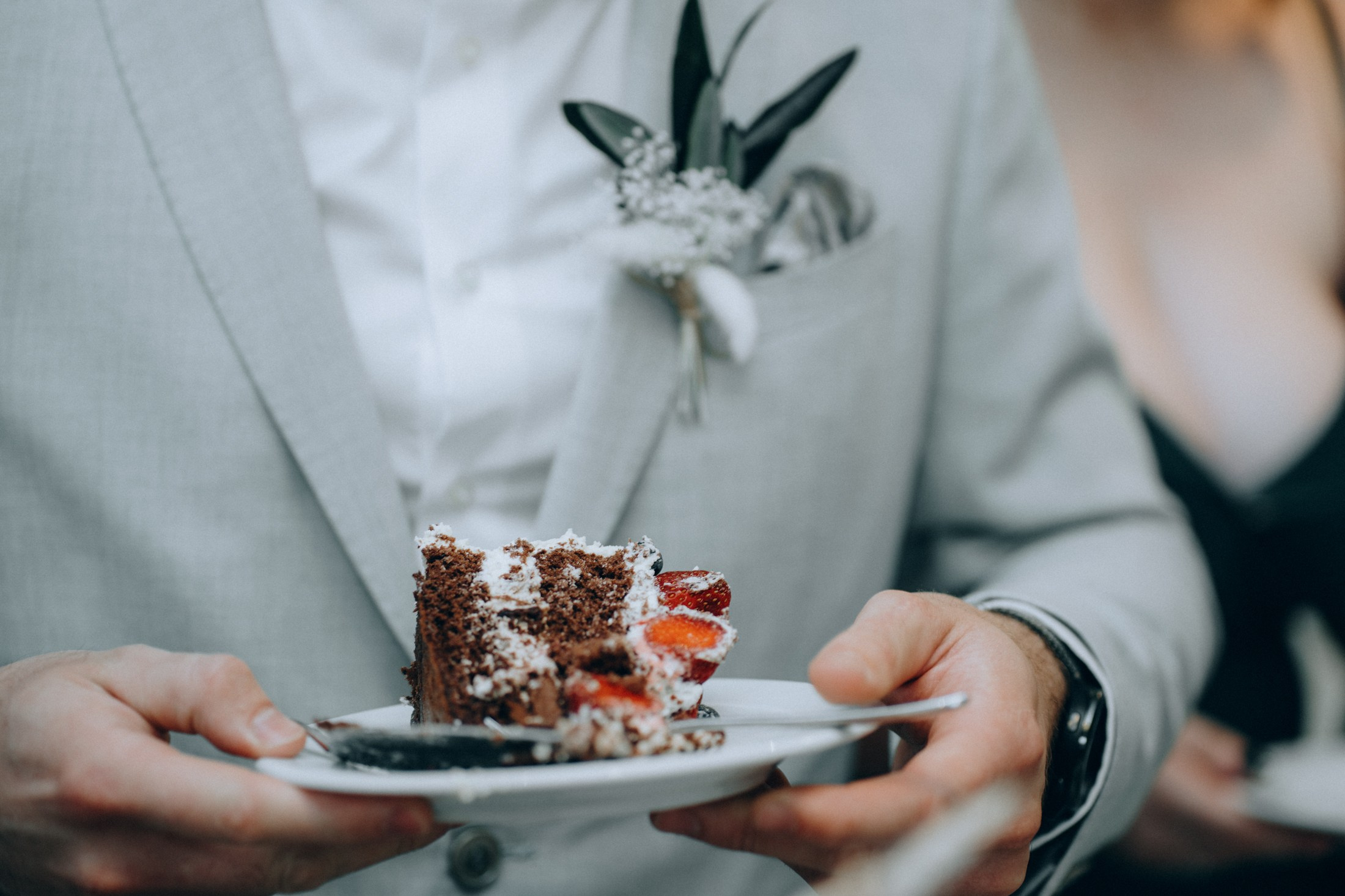 Свадебные детали — руки держат торт с украшением в виде сердец