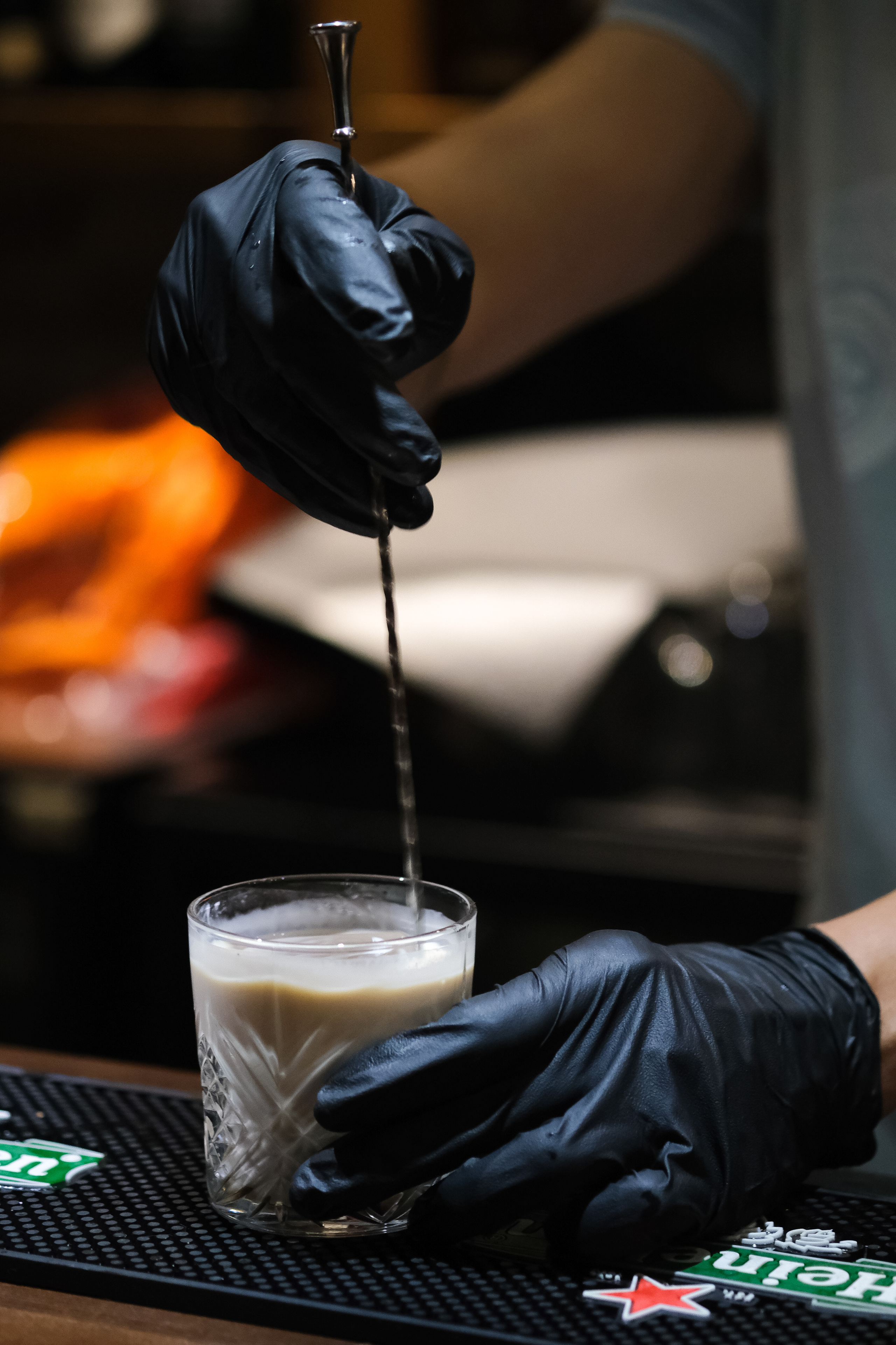 barman in rubber gloves is making cocktail