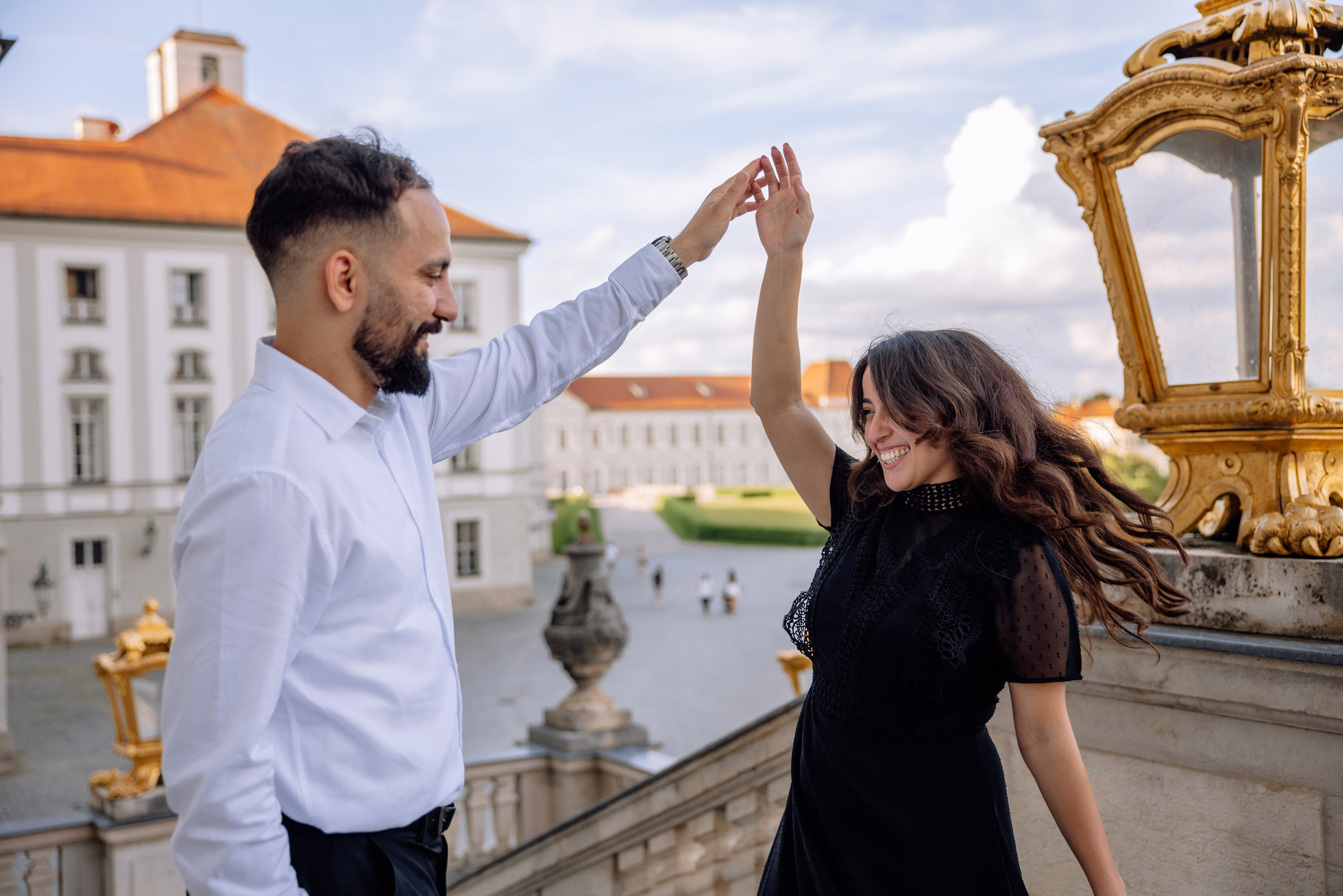 Braut dreht sich in den Armen des Bräutigams vor dem Schloss Nymphenburg