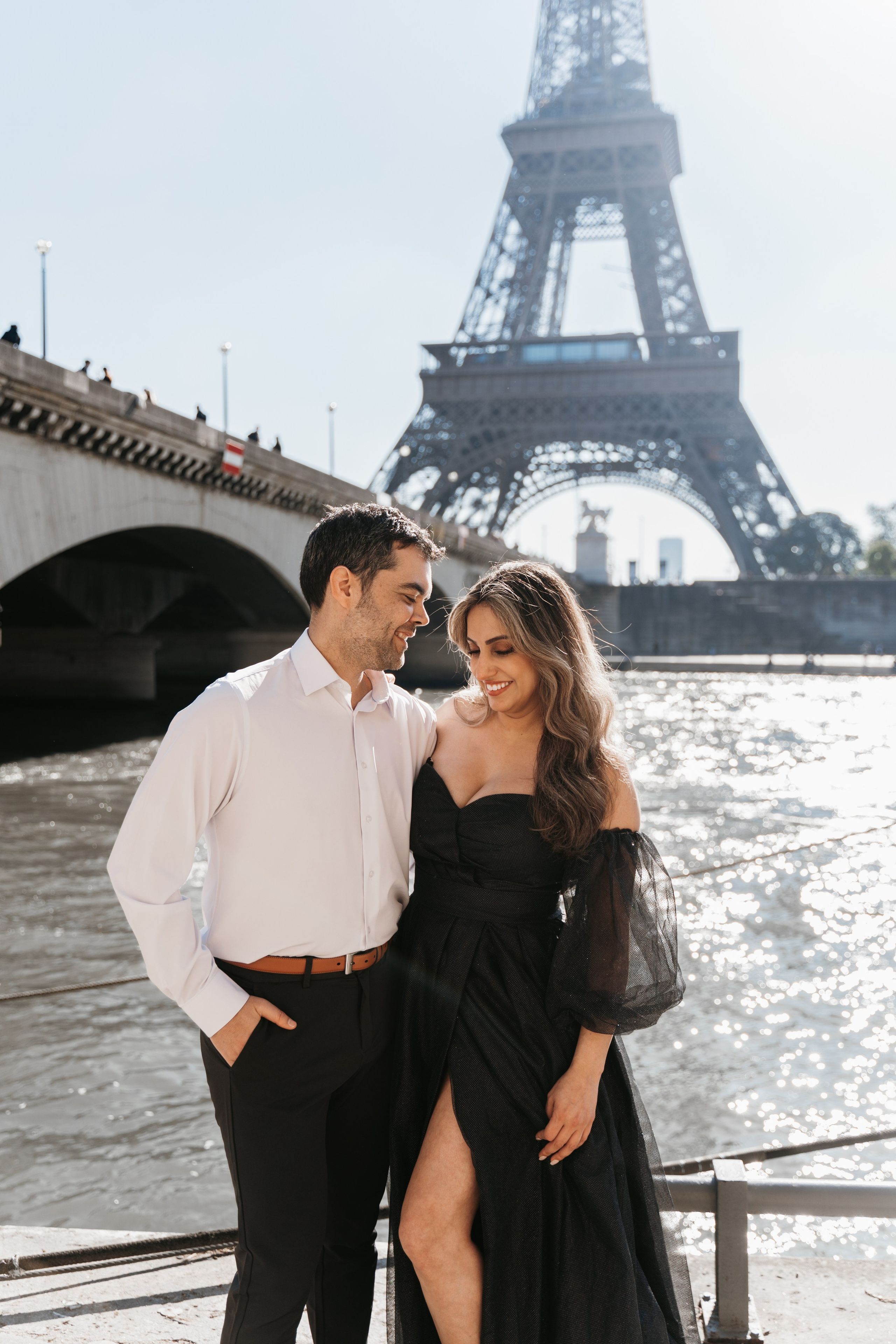 Elegant couple laughing near the river Seine on the sunny day in Paris