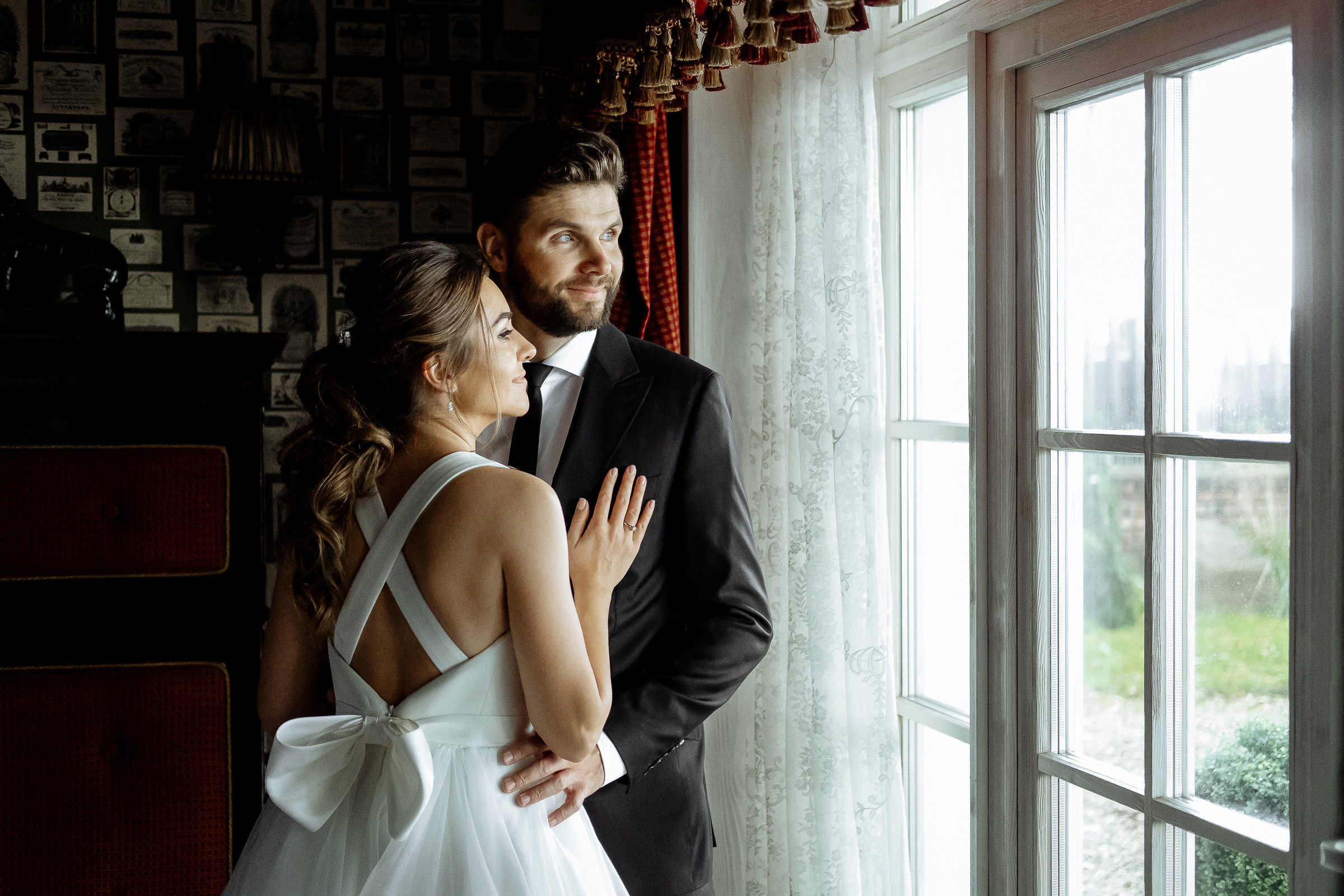 Bride and groom morning portrait by window, by Tanya Bodgan, Cornwall wedding photographer.