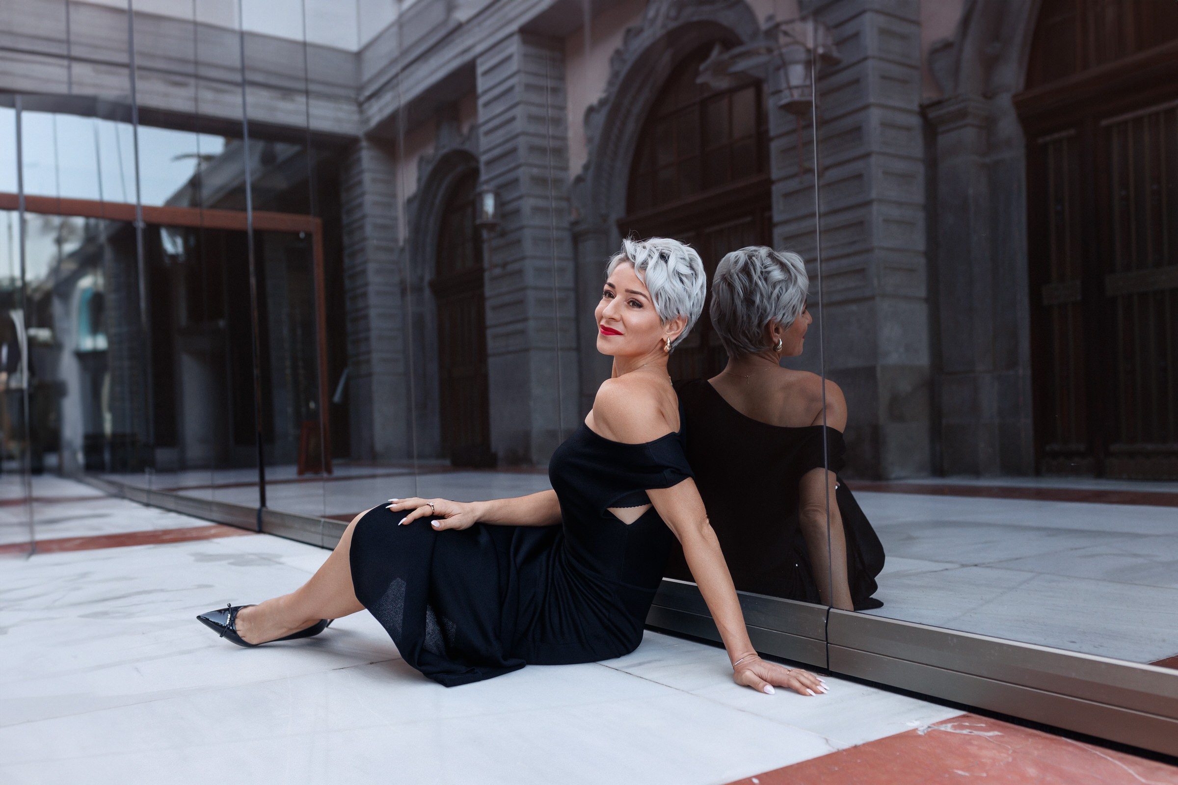 Luxury Hotel Santa Catalina, a Royal Hideaway Photo Shoot A woman in a black dress sitting on the floor of a building.
