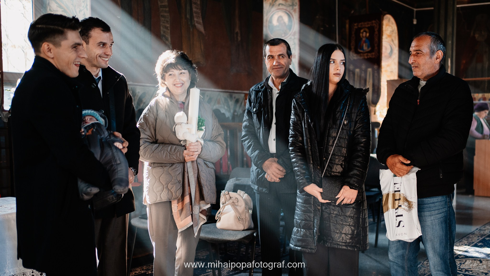 Instantaneu plin de tandrețe dintre părinți și bebeluș în ziua botezului, realizat în ilfov. Fotografie profesională de botez, capturând emoțiile autentice ale familiei într-un decor luminos și cald