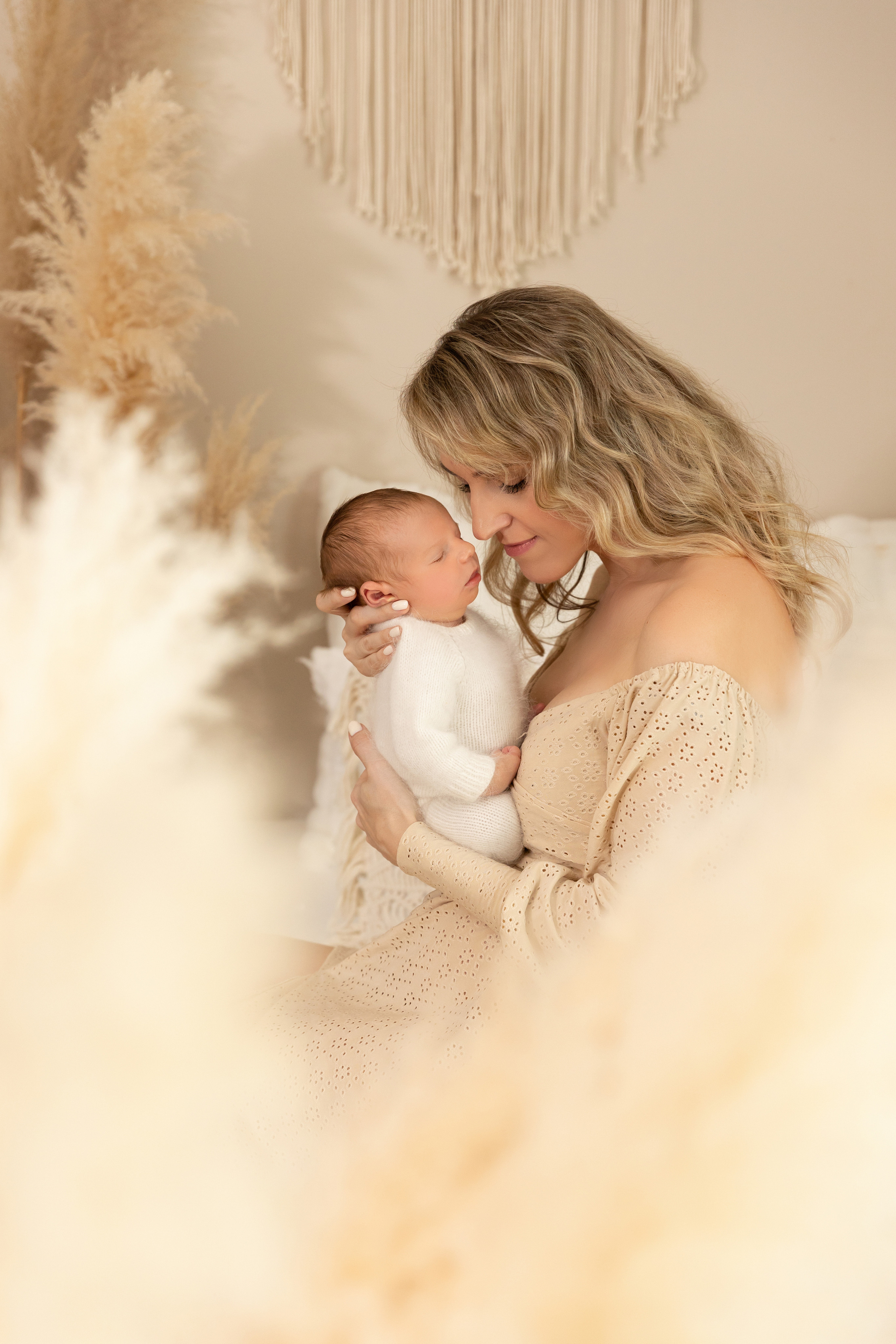 Emotionale Aufnahme einer Mutter, die ihr Neugeborenes liebevoll küsst – Babyfotoshooting in Iserlohn.