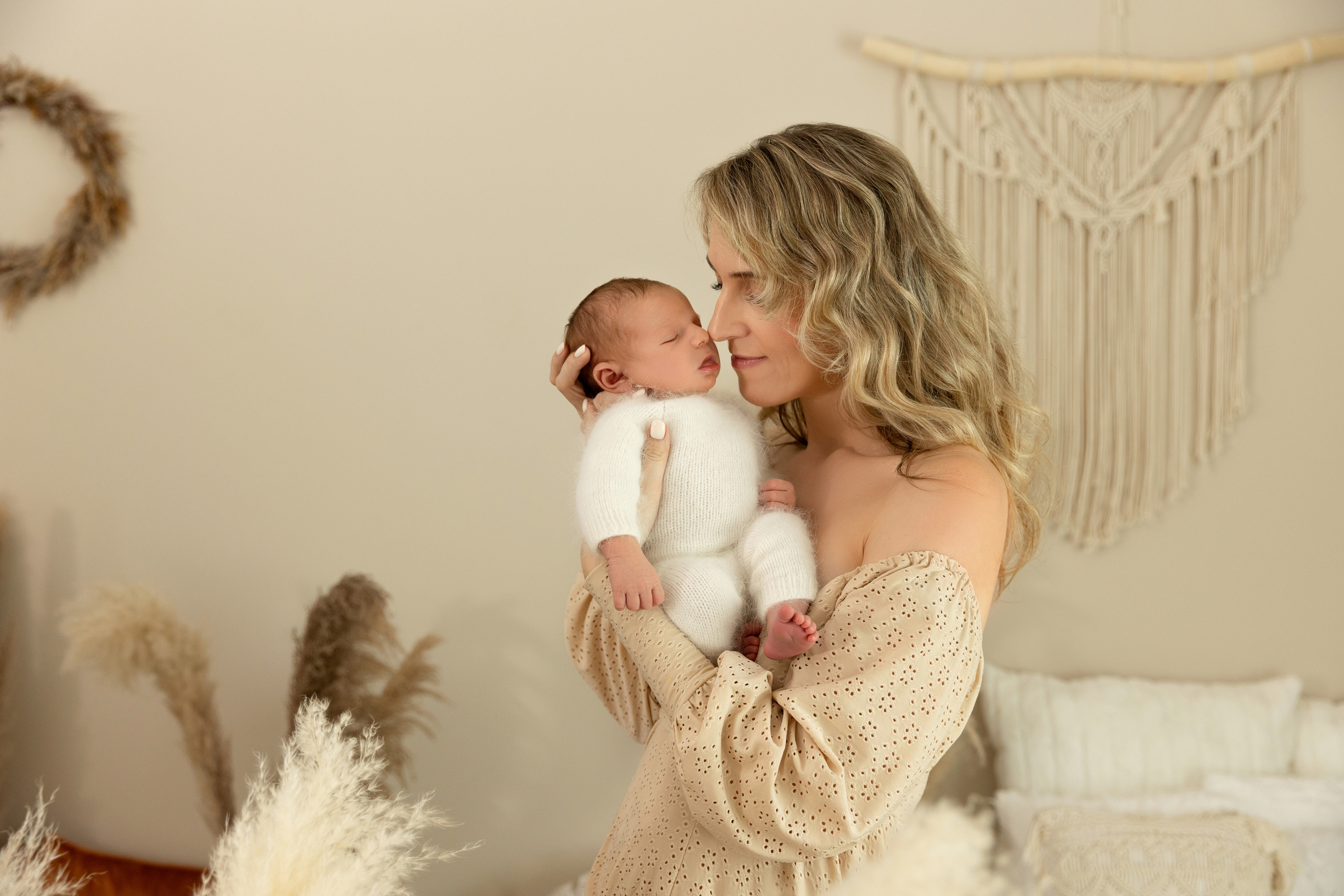 Emotionale Aufnahme einer Mutter, die ihr Neugeborenes liebevoll küsst – Babyfotoshooting in Iserlohn.