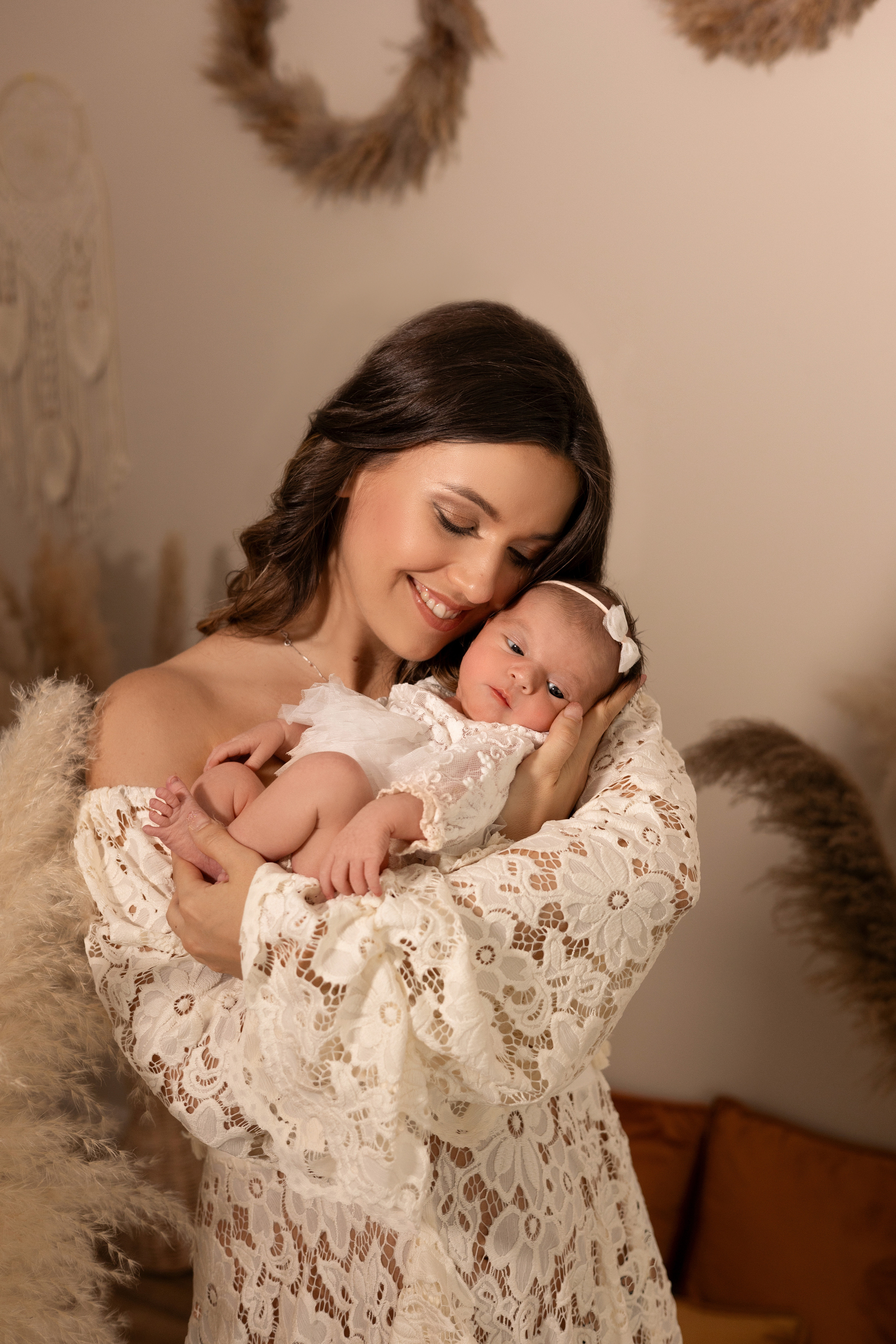 Emotionale Aufnahme einer Mutter, die ihr Neugeborenes liebevoll küsst – Babyfotoshooting in Iserlohn.