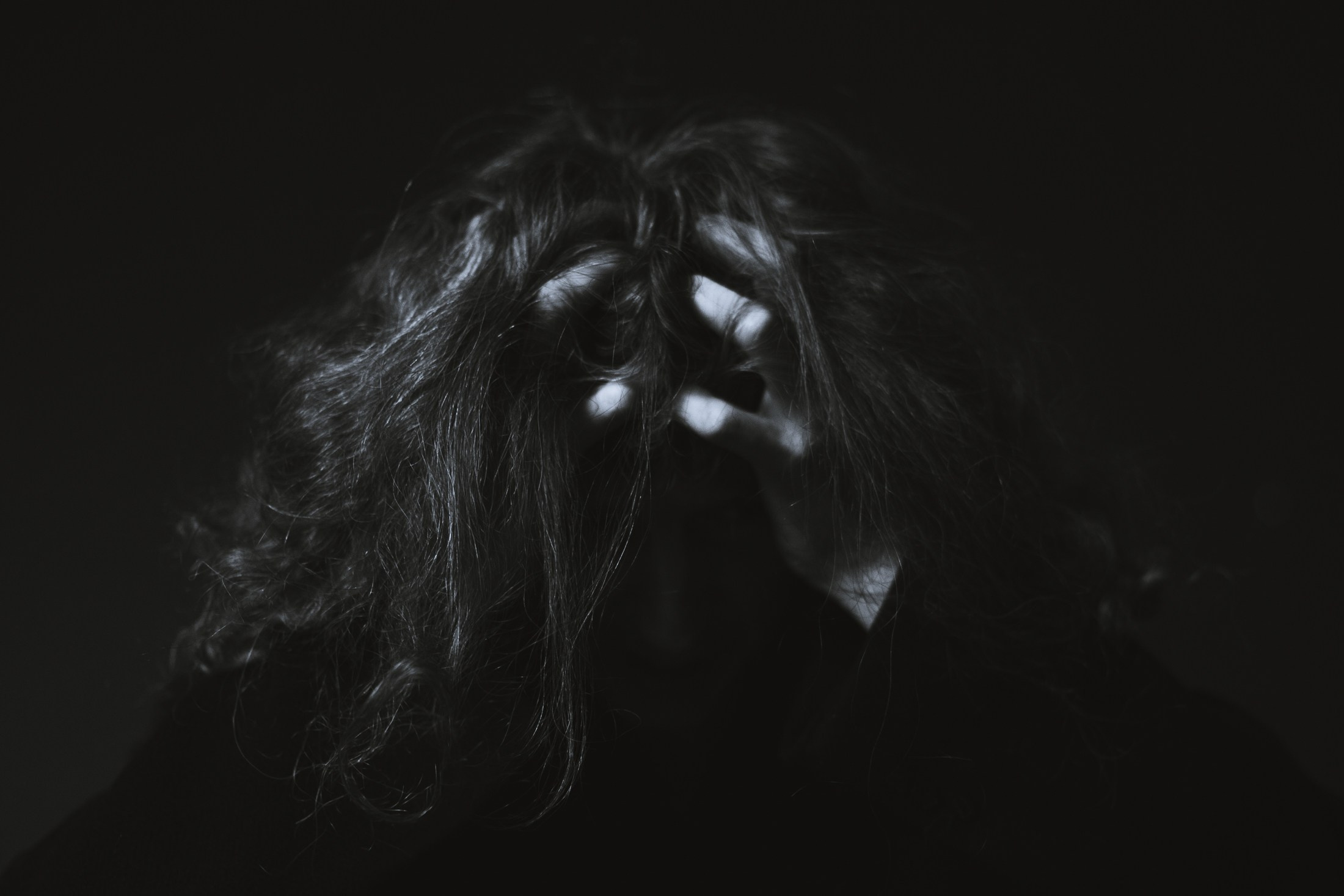 Dramatische Schwarzweiß-Szene mit Händen im Haar – künstlerische Fotografie