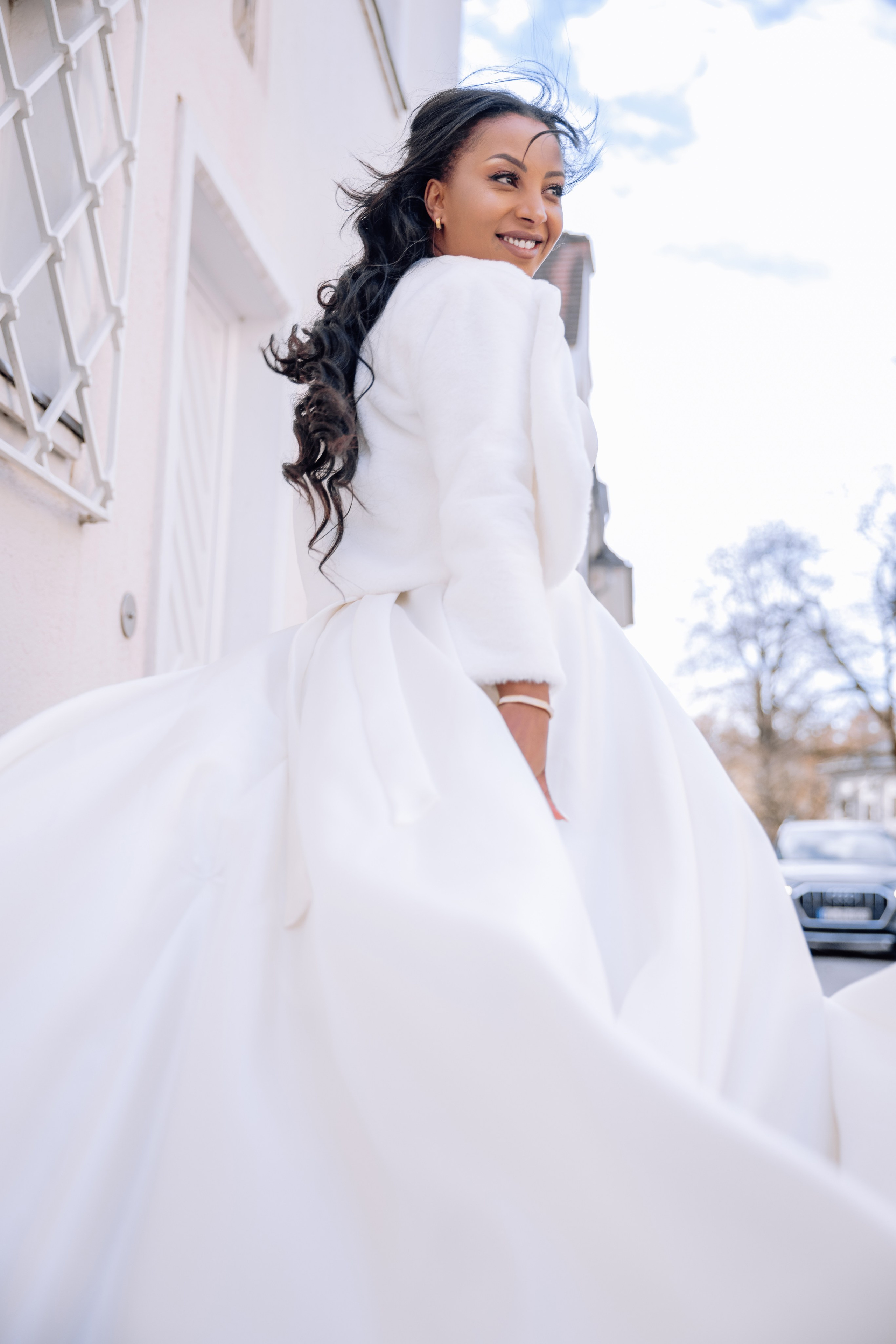 Brauthaar weht im Wind – Kleid bewegt sich elegant vor Standesamt Schwabing