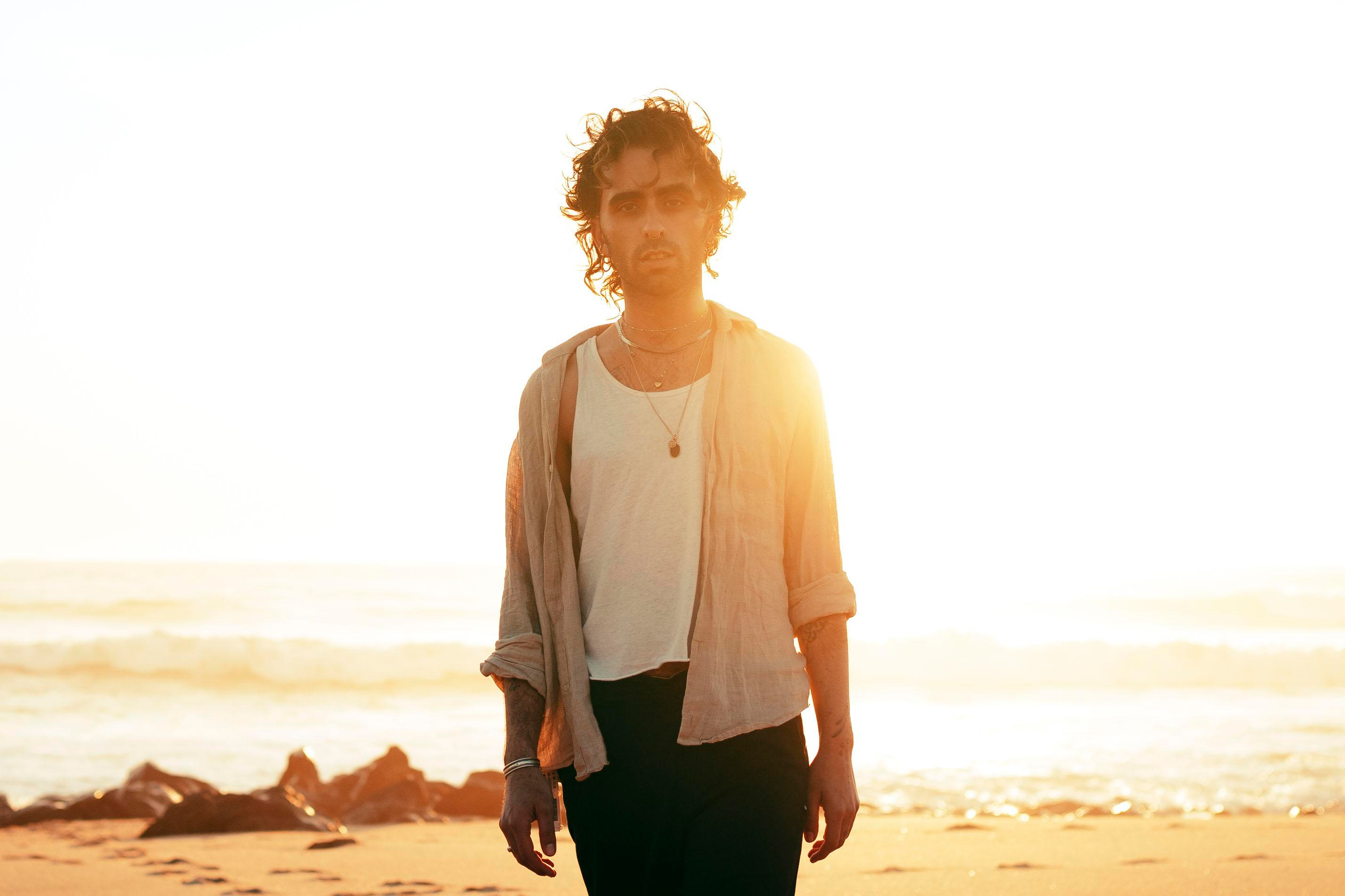 LGBTQ+, LGBT portrait of a beautiful person with makeup, a white tank top, and curly hair.