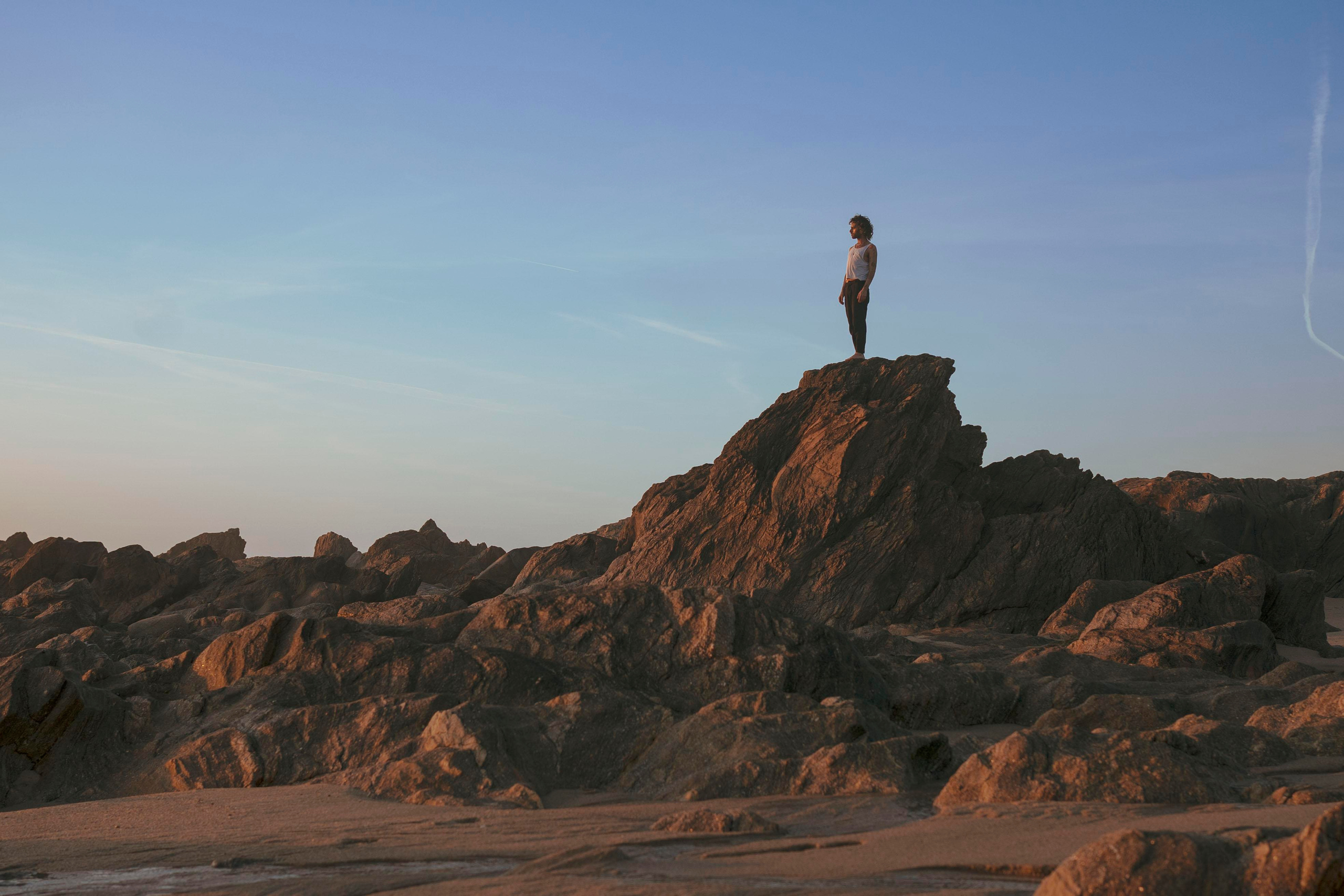 Silhouette of a person standing on a rock. 
