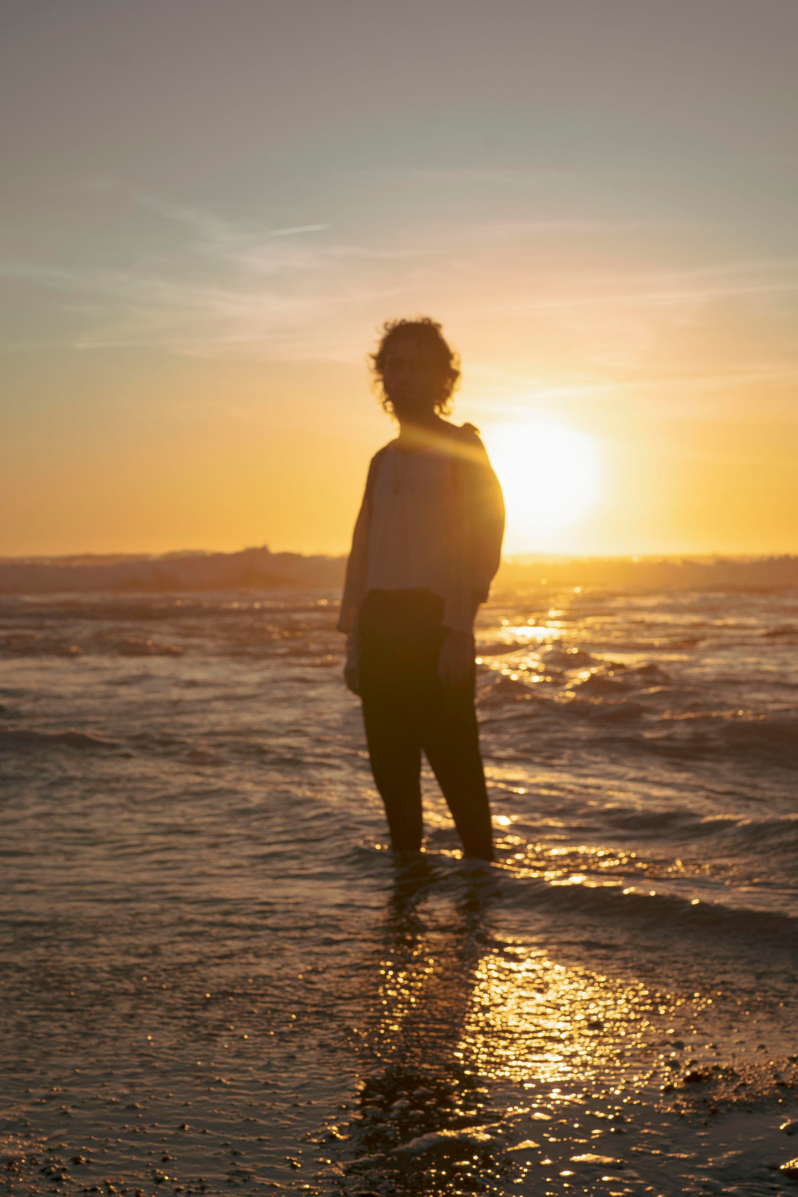 Silhouette of a person with a sunset sky in the background.